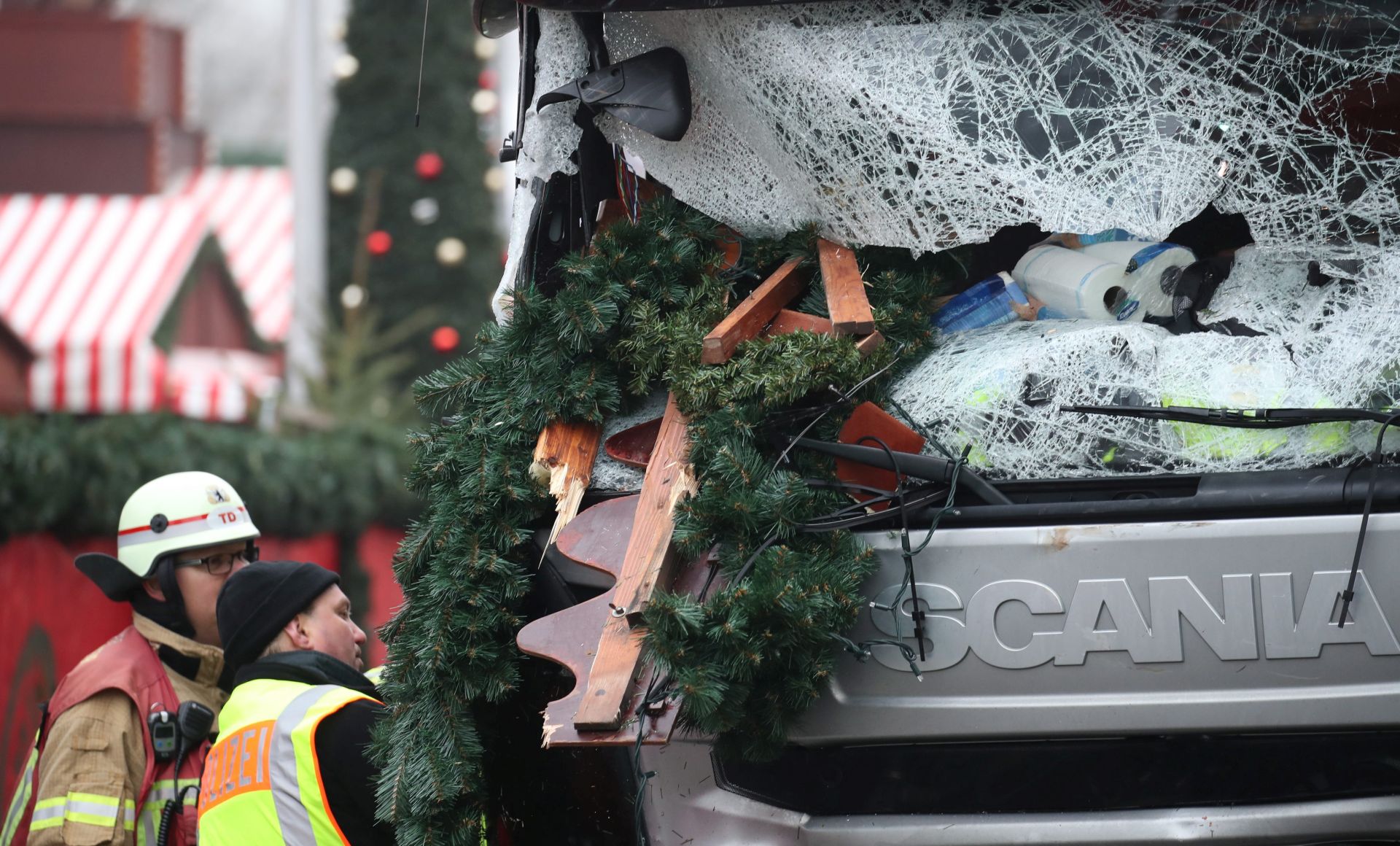 epa05683080 A police officer and fireman inspect a damaged truck on a road beside the Christmas market at Breitscheidplatz in Berlin, Germany, 20 December 2016. According to the police, at least 12 people were killed and at least 48 injured after a truck ploughed into a busy Christmas market in Berlin. Authorities are investigating the incident as a 'possible terrorist attack,' media reported.  EPA/MICHAEL KAPPELER