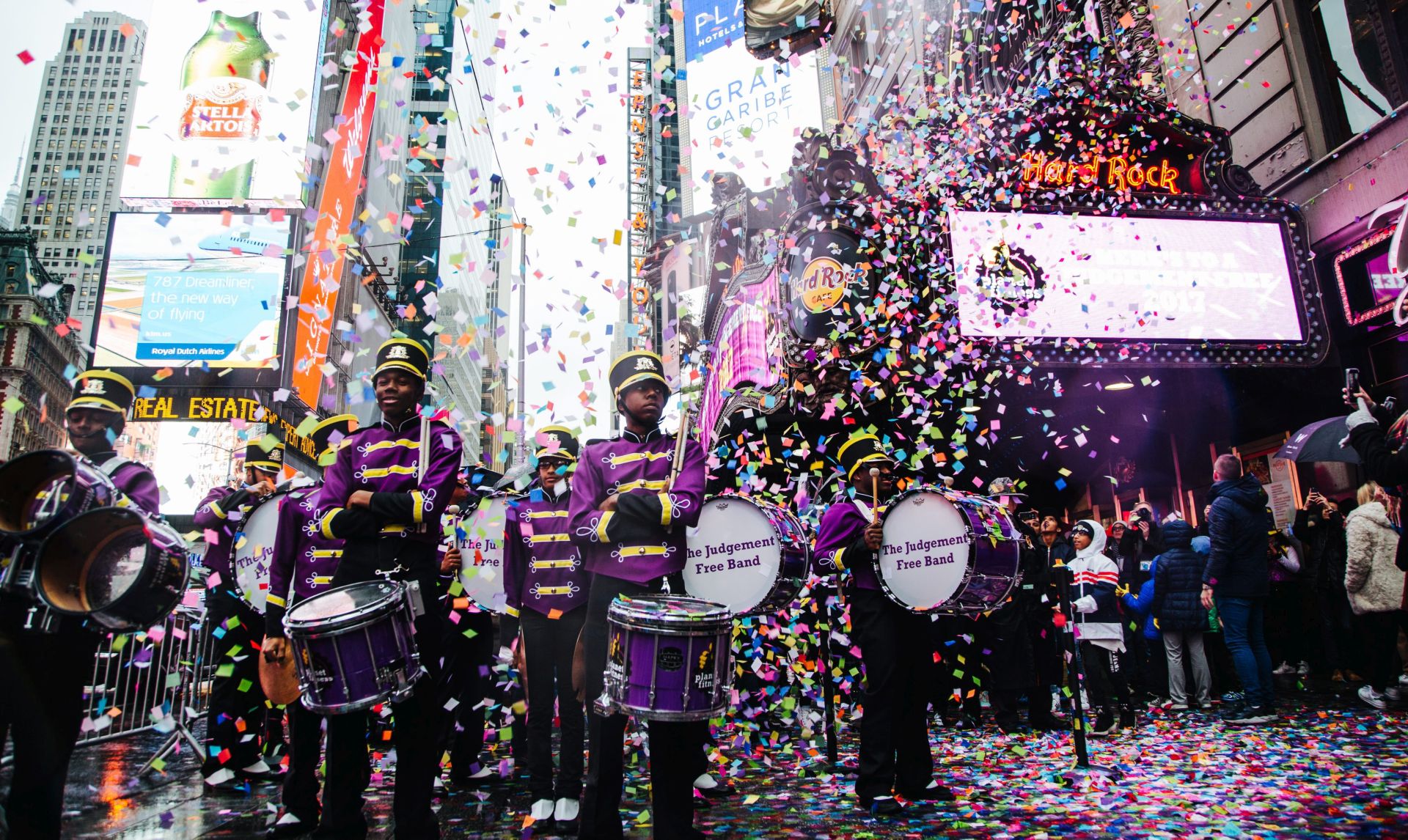 epa05690941 New York City-based Marching Cobras band, welcome the handfuls of confetti that are thrown as a test before New Year Eve from the Hard Rock Cafe marquee in Times Square, New York, New York, USA, 29 December 2016. The colorful event is held in preparation for the release of confetti at midnight on New Year's Eve that will include pieces with wishes from individuals who have submitted them at the New Year's Eve Wishing Wall in Times Square.  EPA/ALBA VIGARAY