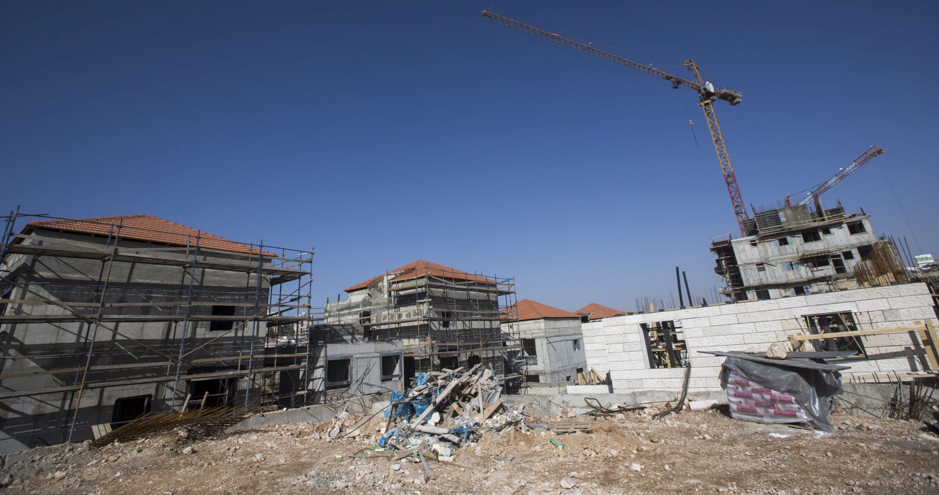 epa05662243 Buildings are under construction in the West Bank Israeli settlement of Pesqat Ze'ev, north of Jerusalem, 06 December 2016. Israel's parliament passed a preliminary vote of a controversial draft law that could lead to the legalization of nearly 4,000 settlers homes in the West Bank. A group of 60 deputies voted for the bill while 49 voted against it. The draft still has to be adopted in three readings before becoming law.  EPA/ATEF SAFADI