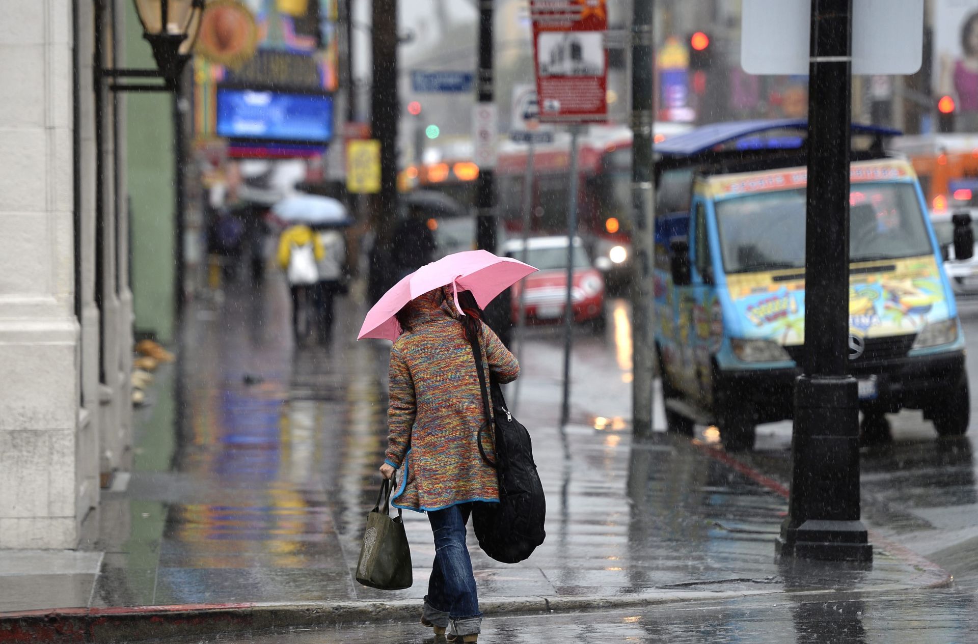 epa05090609 A woman tries to stay dry as she walks  down Hollywood Boulevard in Hollywood, California, USA, 06 January 2016. A series of El Nino generated rain storms which are sweeping through California. Flood watches and concern for debris flows in areas affected by fires has residents and emergency personnel on alert.  EPA/MIKE NELSON