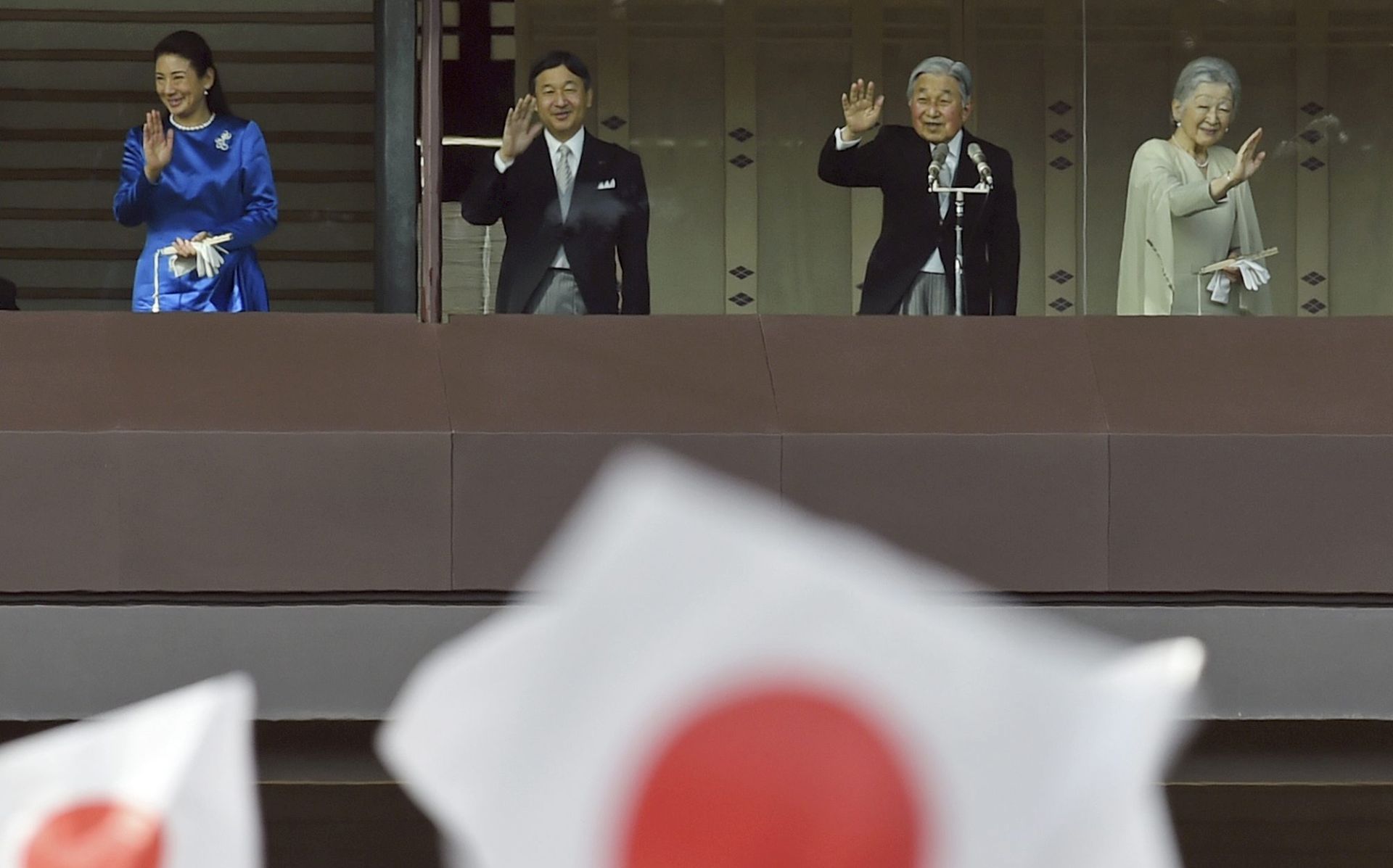 epa05694774 Japan's Emperor Akihito (2-R) and Empress Michiko (R) with Crown Prince Naruhito (2-L) and Crown Princess Masako (L) wave to well-wishers through bullet-proof glass from a balcony during the New Year's public appearance at the Imperial Palace in central Tokyo, Japan, 02 January 2017. Emperor Akihito and royal family members greeted well-wishers for the new year.  EPA/FRANCK ROBICHON
