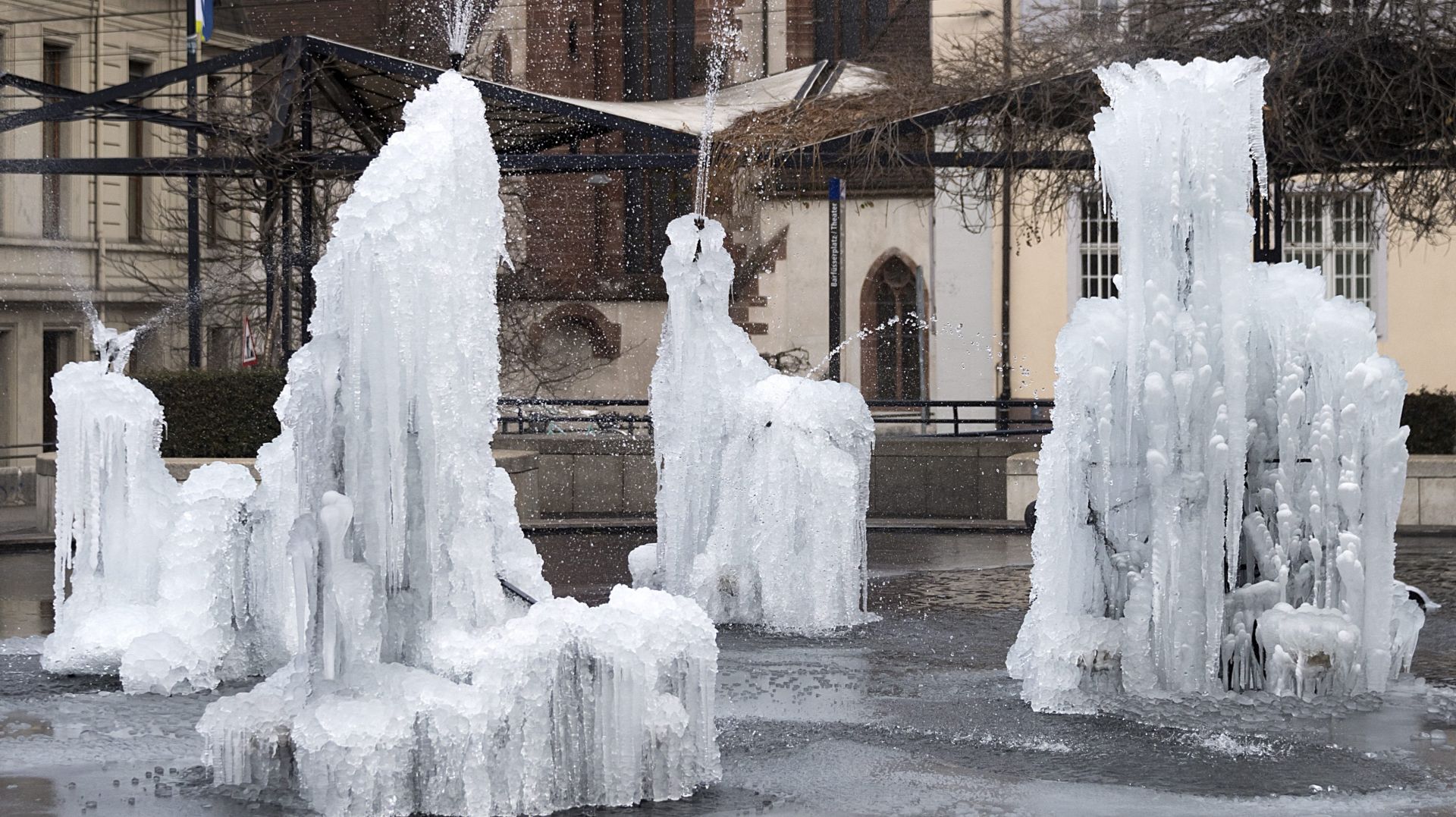 epa05702981 The figures of the Tinguely fountain are crusted with a thick layer of ice following a freezing night, on the Theatre Square in Basel, Switzerland, 07 January 2017.  EPA/GEORGIOS KEFALAS