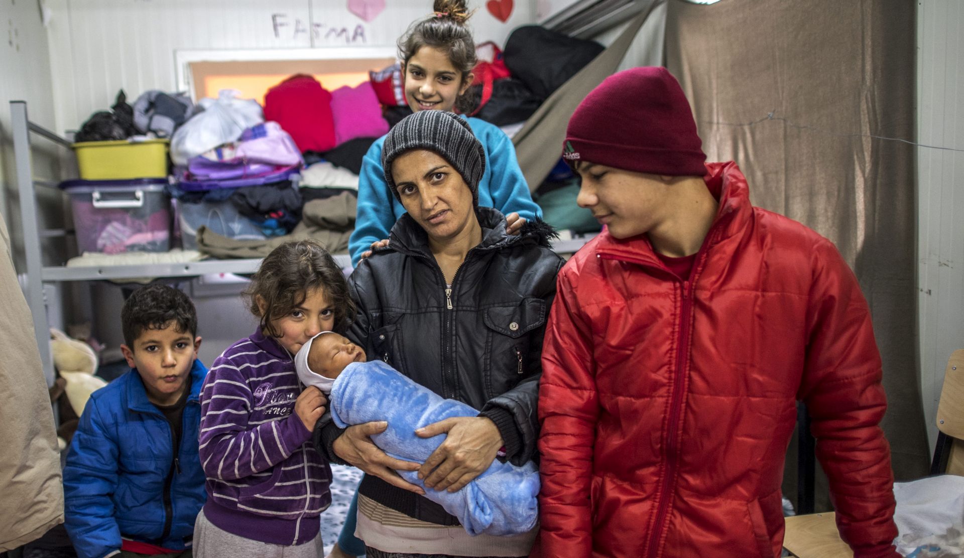 epa05728150 Shirin Kurdi, 32, mother of five children, holds her newly born baby Iljaz Rasul (five days old) in her barrack at the transit center for refugees and migrants near northern Macedonian village of Tabanovce on the border with Serbia, The Former Yugoslav Republic of Macedonia, 18 January 2017. Shirin Kurdi (Syrian Kurd) with her children are stuck in the transit camp for the last 10 months. According to the director of the transit center, Goran Stojanovski, there are currently 102 staying refugees and migrants at the center.  EPA/GEORGI LICOVSKI