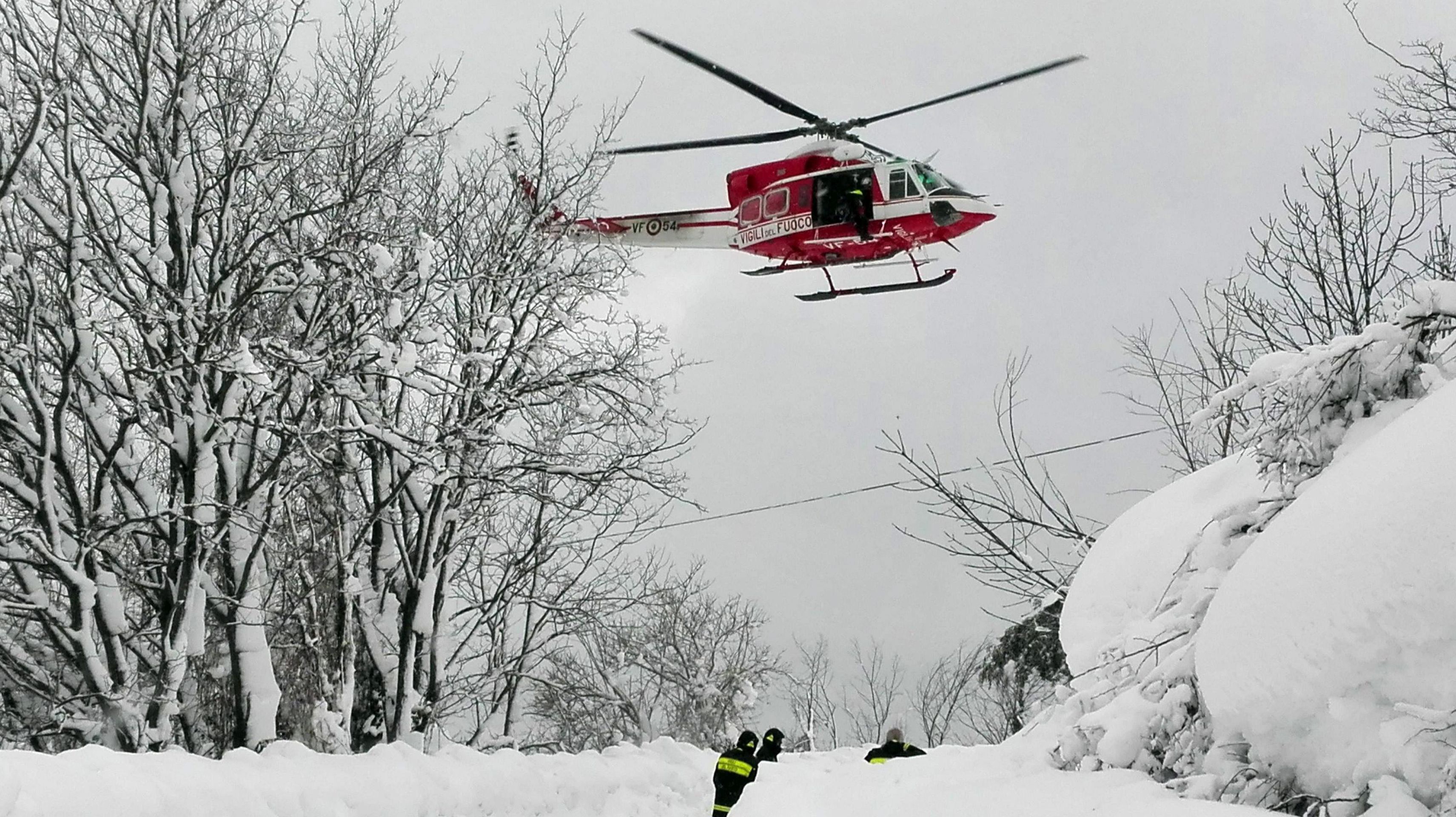 epa05729936 A handout picture provided by rescuers shows a helicopter and rescue workers en route to hotel Rigopiano after it was hit by an avalanche in Farindola (Pescara), Abruzzo region, early 19 January 2017. According to an Italian mountain rescue team, several people have been killed in an avalanche that has hit a hotel near the Gran Sasso mountain in Abruzzo region. Authorities believe that the avalanche was apparently triggered by a series of earthquakes in central Italy on 18 January.  EPA/ITALIAN MOUNTAIN RESCUE HANDOUT BEST QUALITY AVAILABLE HANDOUT EDITORIAL USE ONLY/NO SALES