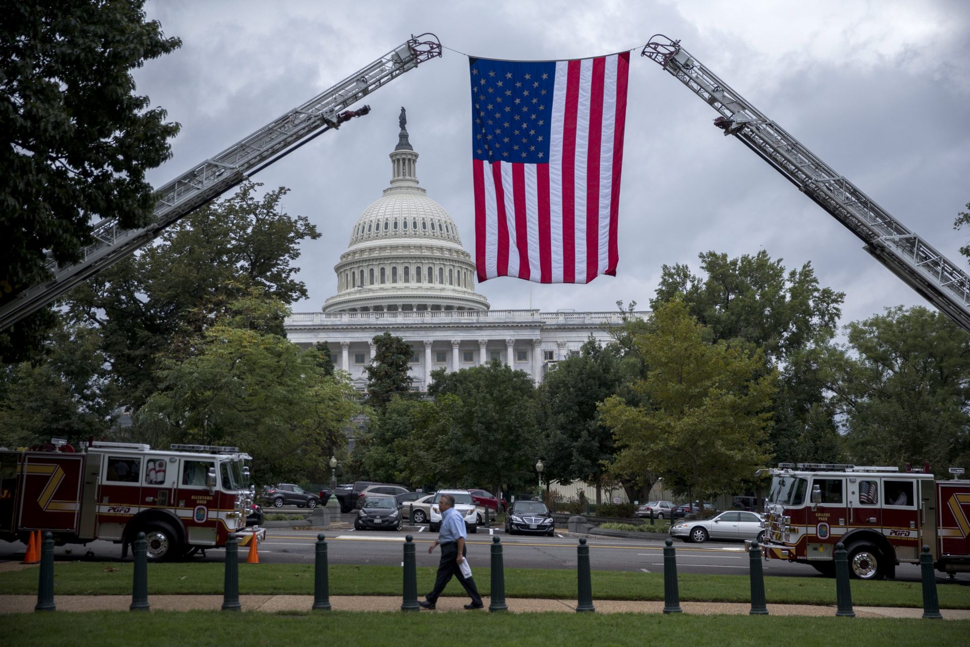 epa05560547 An American flag is suspended from fire department ladder trucks during a successful veto override vote in the Senate at the US Capitol in Washington, DC, USA, 28 September 2016. The Senate voted 97-1 to override President Obama's veto of legislation allowing families of the victims of the 9/11 attacks to sue the government of Saudi Arabia.  EPA/SHAWN THEW