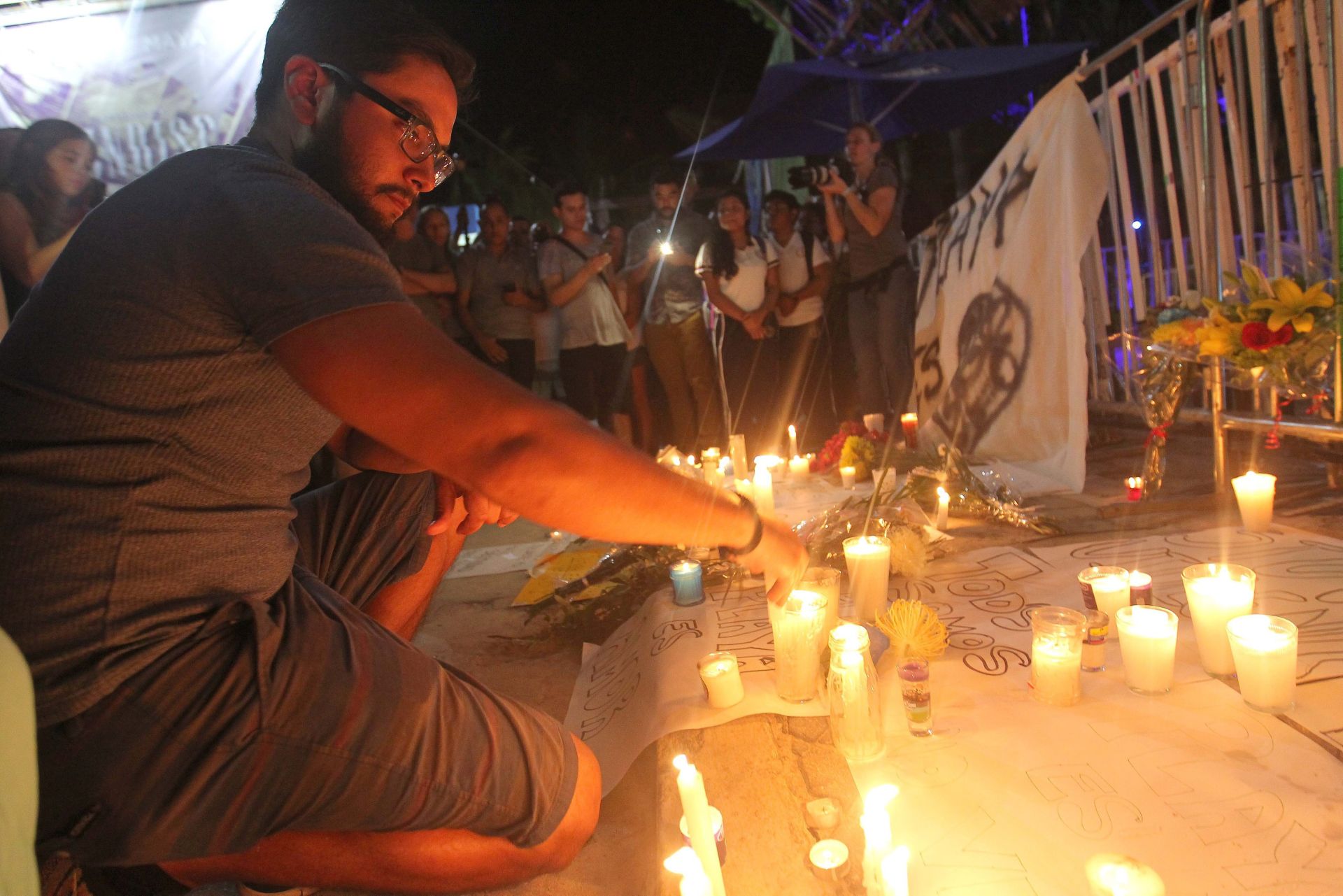 epa05722771 People place candles at a memorial for the victims of a shooting that occurred during the BPM Music Festival at the Blue Parrot Nightclub, in Playa del Carmen, Mexico, 16 January 2017. According to media reports, a lone gunman entered the Blue Parrot nightclub, which was hosting a closing party for the BMP festival, and fired several shots, killing five people and leaving 15 others injured.  EPA/ALONSO CUPUL