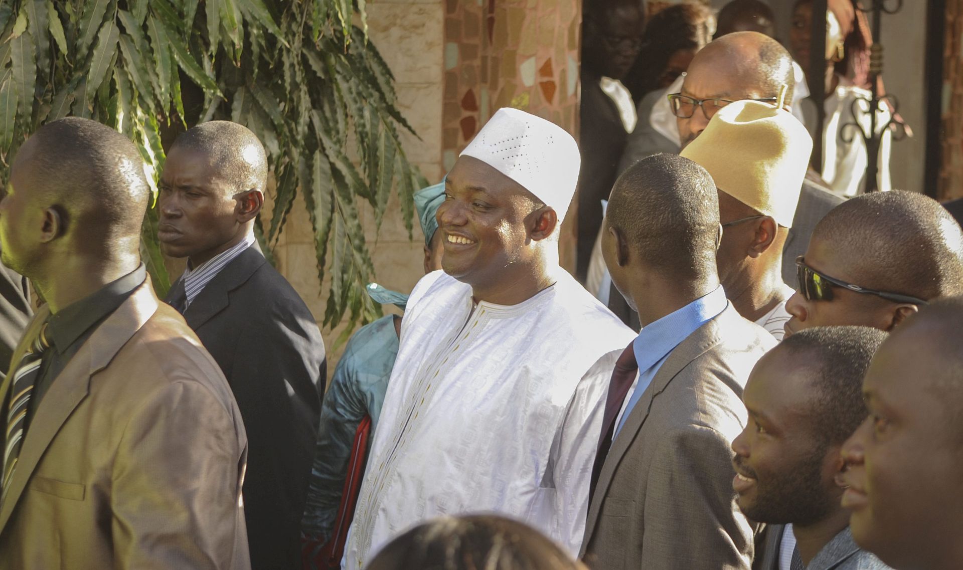 epa05732056 President-elect of Gambia Adama Barrow (C) smiles at supporters cheering, after he was sworn in as president at the Gambia embassy in Dakar, Senegal, 19 January 2017. West African military forces are moving in to enforce the transfer of power removing President Yahya Jammeh following his refusal to accept election results.  EPA/STR