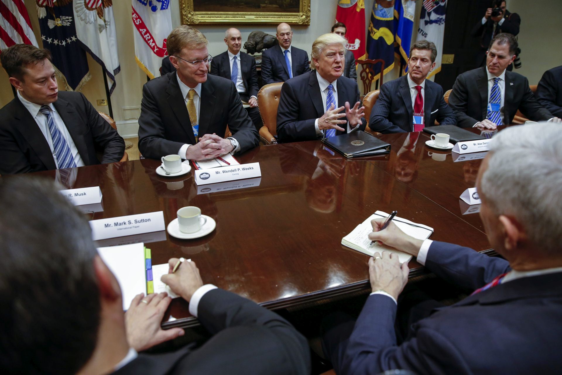 epa05744611 US President Donald J. Trump (C), with the Tesla and Spacex CEO Elon Musk (L), CEO of Corning Wendell Weeks (2-L), CEO of Johnson & Johnson Alex Gorsky (2-R) and CEO of Dell Technologies Michael Dell (R), delivers remarks in a meeting with business leaders in the Roosevelt Room of the White House in Washington, DC, USA, 23 January 2017. Others are not identified. President Trump was set for a day of meetings with Business leaders, Union leaders, Congressional leaders and meeting with Speaker of the House, Paul Ryan later this afternoon.  EPA/SHAWN THEW
