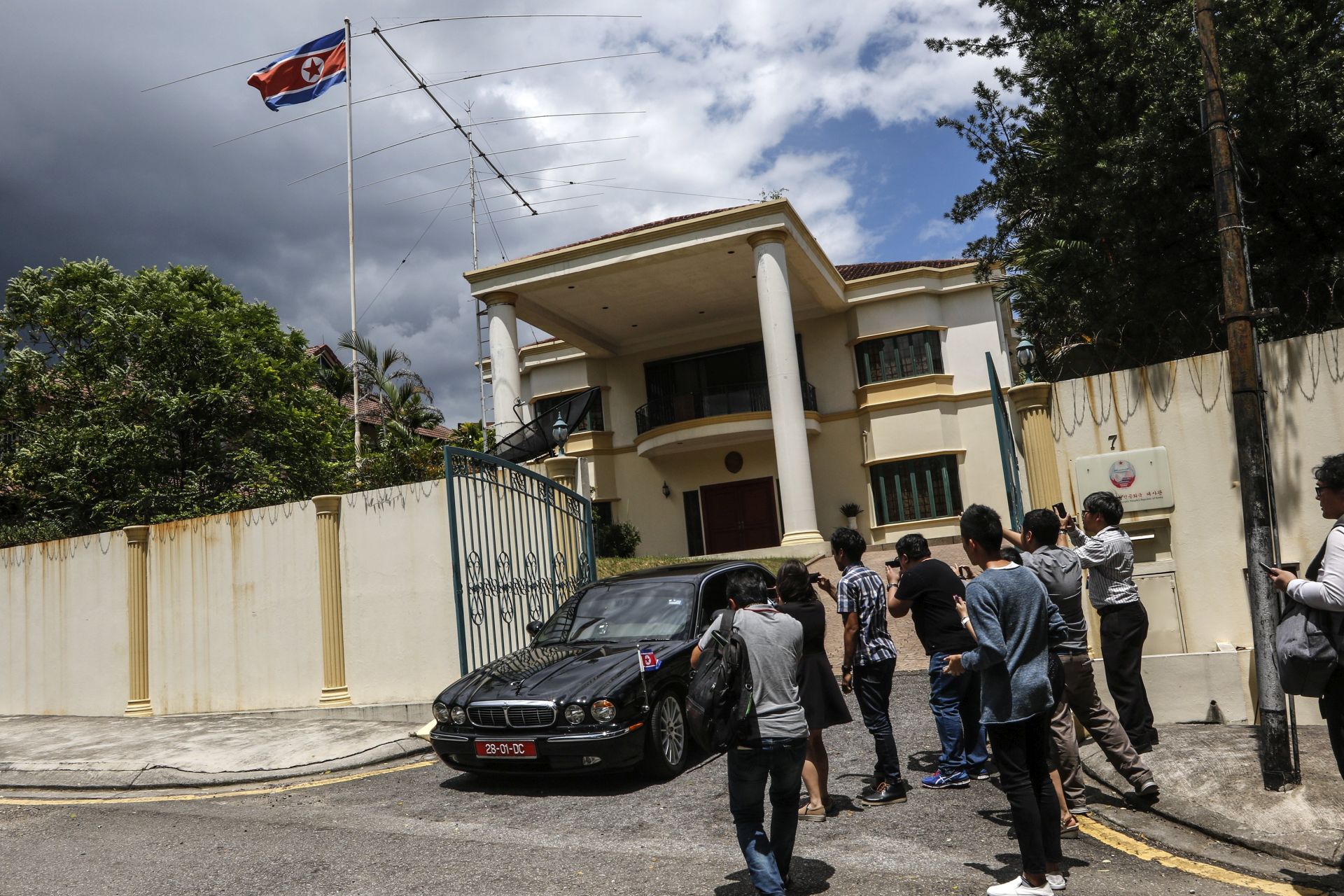 epa05794145 A diplomatic vehicle leaves the North Korean Embassy as members of the media crowd near the building's main entrance, in Kuala Lumpur, Malaysia, 15 February 2017. A press statement released by the Malaysian Royal Police on 14 February 2017, said a 46-year-old North Korean named Kim Chol died the previous day on his way to a hospital from a Malaysia International Airport service counter where he sought initial medical treatment. Reports said Kim Chol, an alias used by Kim Jong-nam, was attacked by two unidentified women with chemical sprays. The Malaysian police are conducting an investigation and a post-mortem examination is expected to be completed soon.  EPA/AHMAD YUSNI