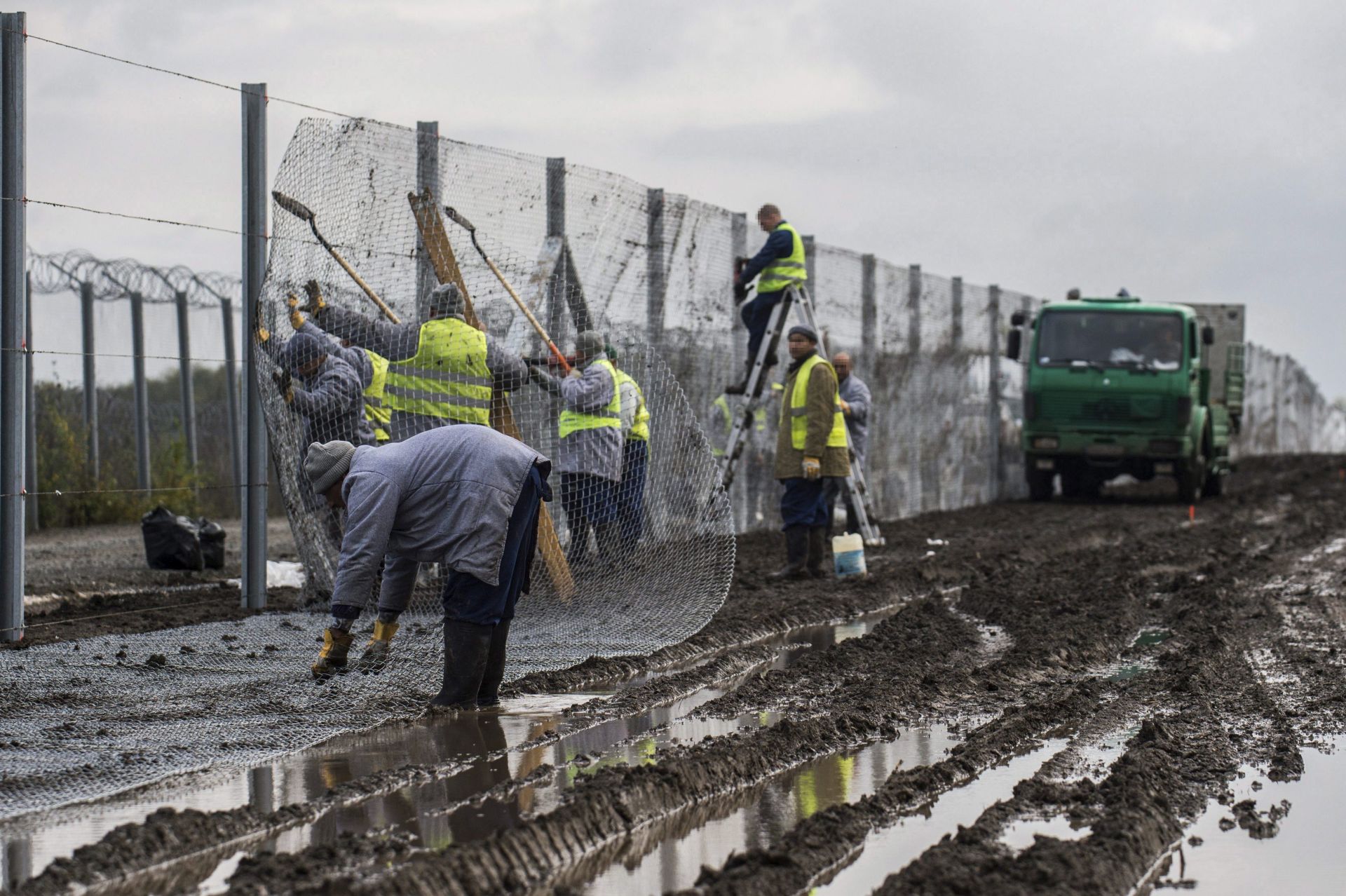 epa05606793 Hungarian convicts install an experimental section of the second line of the border fence at the Hungarian-Serbian border near the village of Gara, 213 kms south of Budapest, Hungary 28 October 2016. The 10.3 kilometer long section is constructed between Gara and Bacsszentgyorgy to reinforce the primary fence that prevents illegal migrants using the Balkan route from entering Hungary.  EPA/SANDOR UJVARI HUNGARY OUT