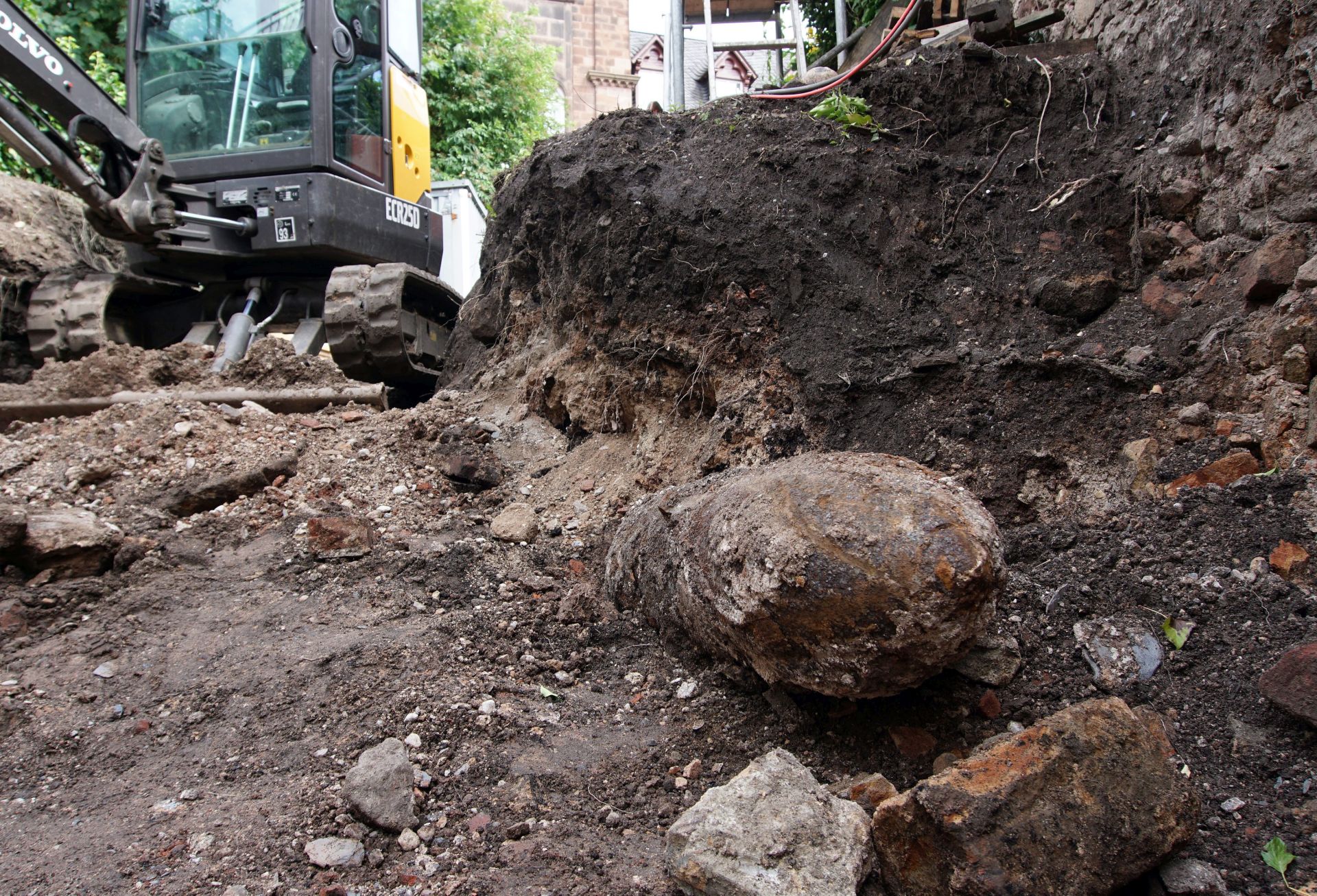epa05399400 A British WWII aerial bomb (C-R) lies in the earth of a construction site in the centre of Trier, Germany, 30 June 2016. The 250 kilogram bomb was found during construction works and will be defused in the evening of 01 July 2016. An evacuation zone will be vacated within a radius of of 500 metres from the bomb. Around 6,000 residents are affected by the security measures.  EPA/HARALD TITTEL