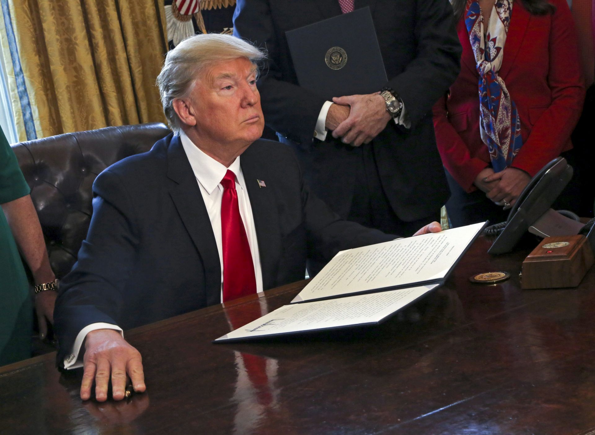 epa05769557 US President Donald J. Trump poses after signing an executive order in the Oval Office of the White House, in Washington, DC, USA, 03 February 2017. Trump signed several executive orders including an order to review the Dodd-Frank Wall Street to roll back financial regulations of the Obama era.  EPA/Aude Guerrucci / POOL