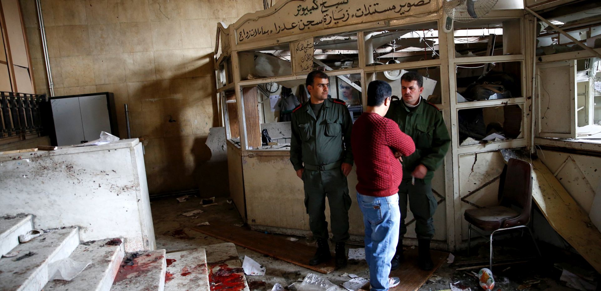 epa05849991 Security personnel stand near a blood stain at the Justice Palace following a suicide bombing in the Hamidiya district of Damascus, Syria, 15 March 2017. According to state-media reports, a suicide bomber attacked the Palace of Justice in the Hamidiya district of Damascus, killing at least 39 people.  EPA/YOUSSEF BADAWI ATTENTION EDITORS: PICTURE CONTAINS GRAPHIC CONTENT