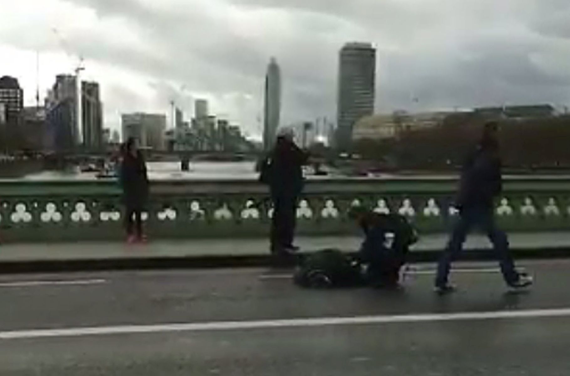 epa05863613 A video grabbed still image, made available by former Polish foreign minister Radoslav Sikorski, showing people attending to a an unured person at the Wstminster Bridge, near the Houses of Parliament in central London, Britain 22 March 2017. Scotland Yard said on 22 March 21017 the police were called to a firearms incident in the Westminister palace grounds and on Westminster Bridge amid reports of several people injured in central London.  EPA/RADOSLAV SIKORSKI BEST QUALITY AVAILABLE