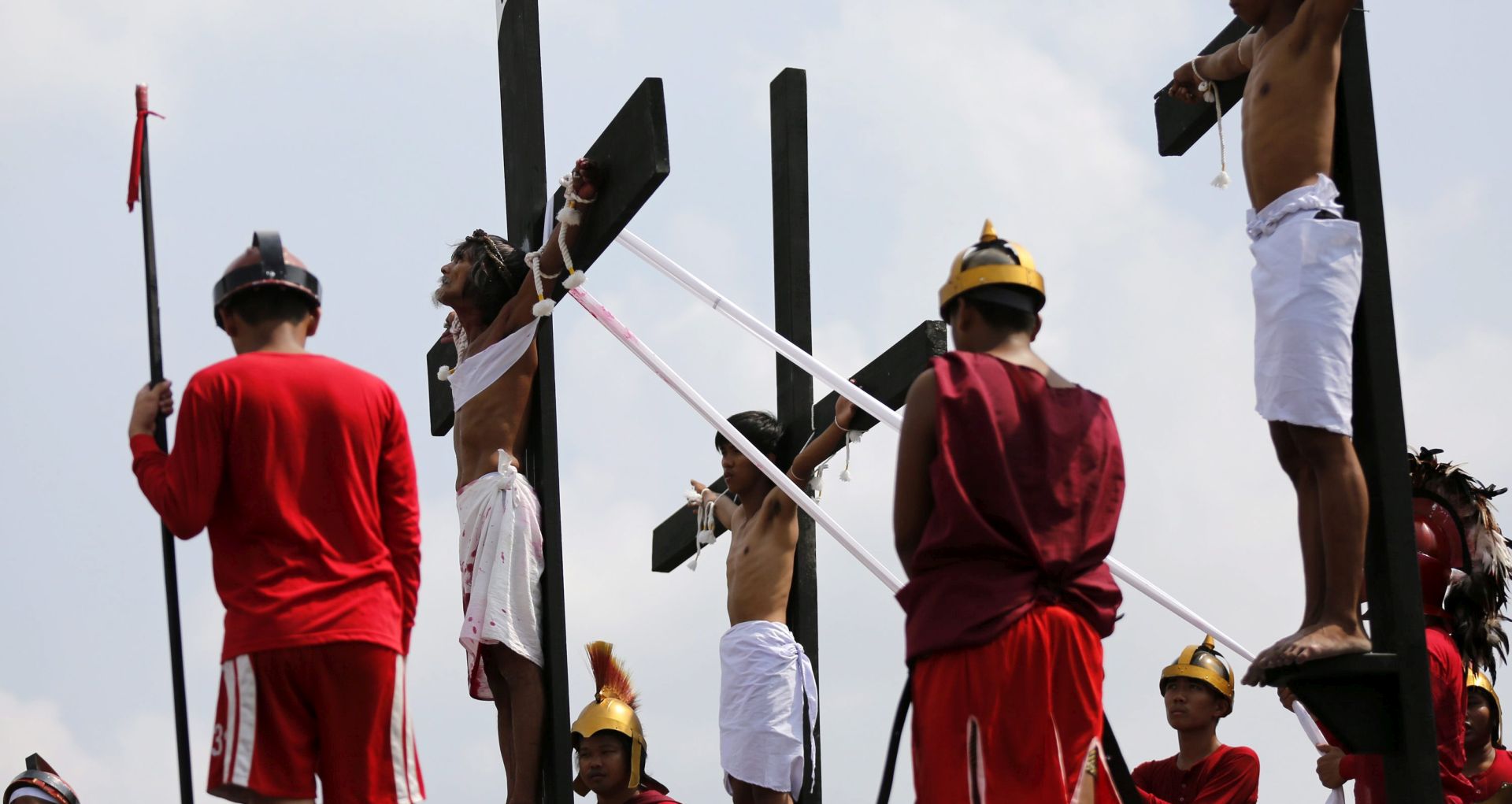 epa05230139 The scene of the crucifixion of Jesus Christ is re-enacted by villagers during the religious rites on Good Friday in San Pedro Cutud village, San Fernando city, north of Manila, Philippines, 25 March 2016. Thousands of Catholic devotees witnessed dozens of men who were nailed to wooden crosses or flogged themselves bloody in annual rituals re-enacting the crucifixion of Jesus Christ.  EPA/FRANCIS R. MALASIG