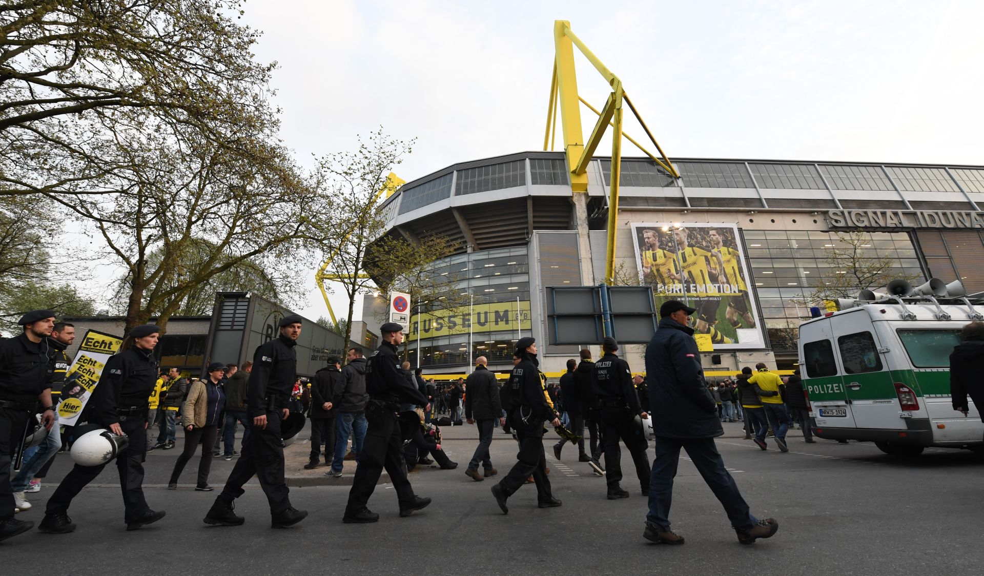 Police officers and fans in front of the Signal Iduna Park in Dortmund, Germany, 11 April 2017. The first leg of the Champions League quarter final soccer match between Borussia Dortmund and AS Monaco had been due to be held in the stadium before being cancelled. Photo: Bernd Thissen/dpa