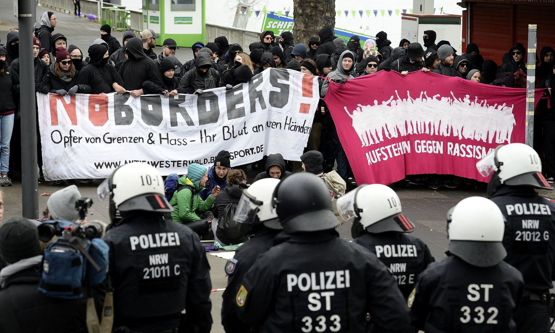 epa05920582 German police in riot gear face protesters of a rally against the 'Alternative for Germany' (AfD) party conference in Cologne, Germany, 22 April 2017. Germany's right-wing Alternative for Germany (AfD) party will gather at the Maritim Hotel Cologne for their federal convention on 22 and 23 April 2017. According to reports, some 50,000 people including thousands of left-wing demonstrators take part in the protest aimed at massively disturbing or even shutting down the AfD's convention.  EPA/SASCHA STEINBACH