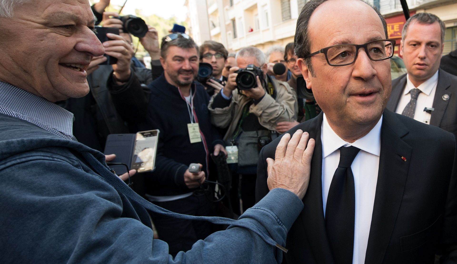 epa05922585 French President Francois Hollande (R) leaves the polling station after casting his ballot in the first round of 2017 French presidential elections at a polling station in Tulle, central France, 23 April 2017. Others are not identified. France goes to the polls in the secound round presidential election on 07 May 2017.  EPA/CAROLINE BLUMBERG