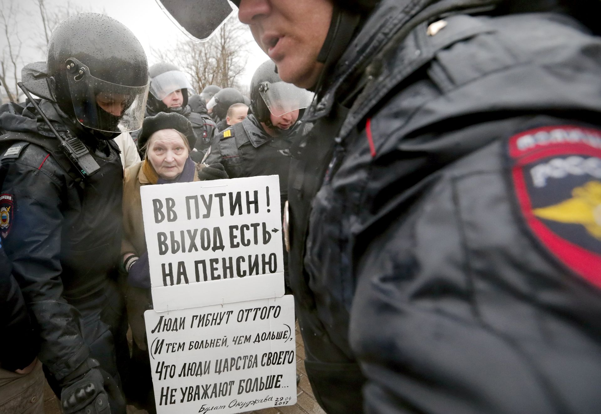 epa05934916 Russian riot policemen detain a demonstrator holding a placard reading, 'Putin to retire' during an opposition rally in central St. Petersburg, Russia, 29 April 2017. According to reports, dozens of demonstrators of the opposition party 'Open Russia' have been detained  when they held an unsanctioned rally 'Nadoel' (Bored) against Russian President Vladimir Putin.  EPA/ANATOLY MALTSEV