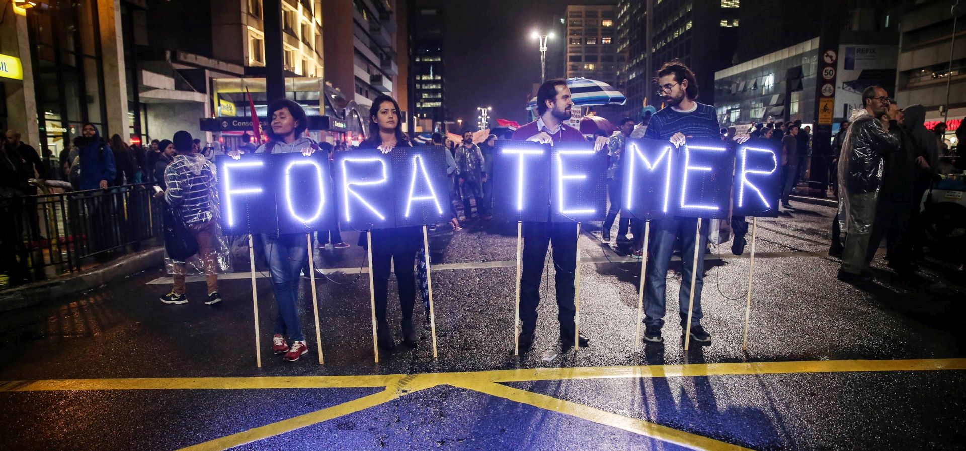 epa05973240 Demonstrators protest against the Government of Brazilian President Michel Temer, at the Paulista Avenue, in Sao Paulo, Brazil, 18 May 2017. Thousands of people took to the streets in the principal cities of Brazil to protest against the government of Michel Temer, over allegations he is involved in a corruption scandal and attempts to obstruct justice. The sign held by the protestors reads: 'Out Temer.'  EPA/FERNANDO BIZERRA JR.