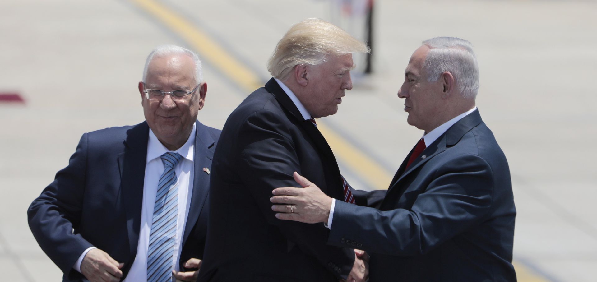 epa05981012 Israeli Prime Minister Benjamin Netanyahu (R) greets US President Donald J. Trump (C) next to Israeli President Reuven Rivlin (L) during a welcoming ceremony at Ben Gurion Airport in Lod, outside Tel Aviv, Israel, 22 May 2017. Trump arrived for a 28-hour visit to Israel and the Palestinian Authority areas on his first foreign trip since taking office in January.  EPA/JIM HOLLANDER