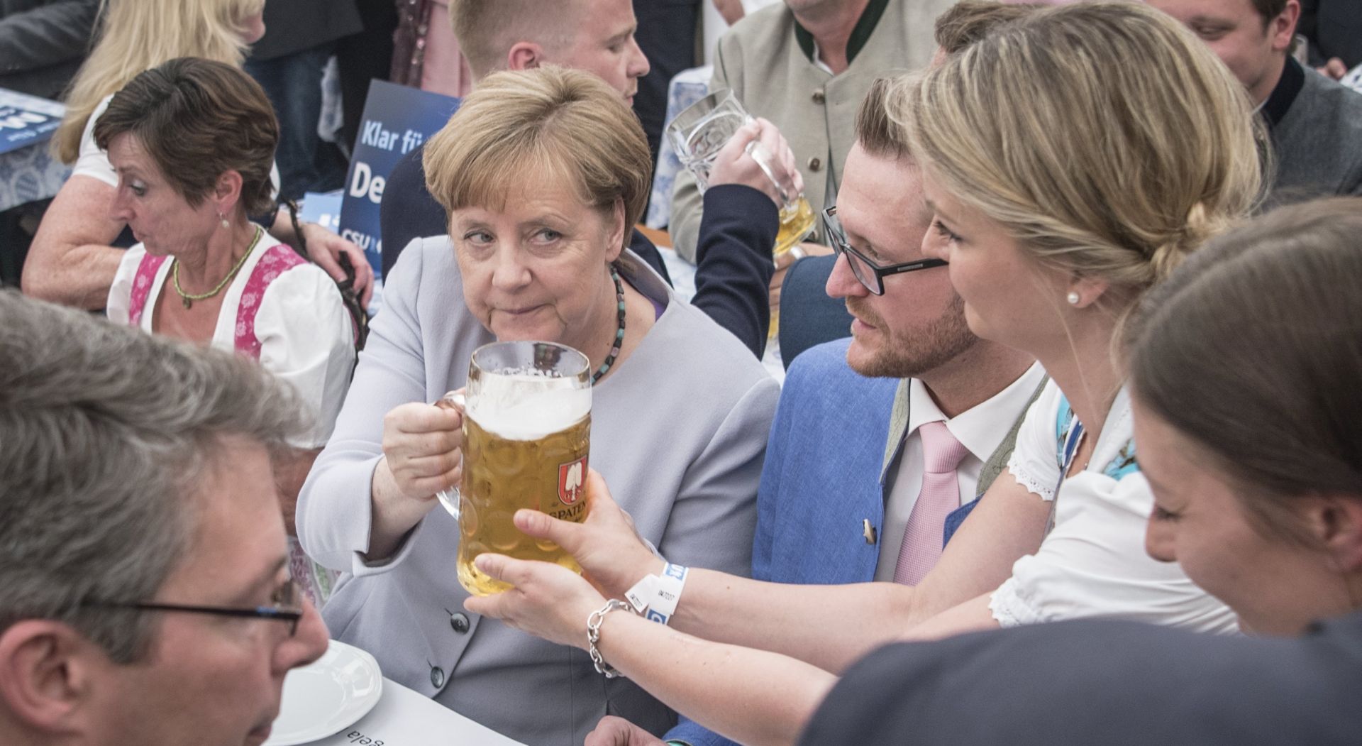 epa05995478 Germany's Christian Democratic Union (CDU) party chairwoman and German Chancellor Angela Merkel receives a glass of beer during an election campaign event of the German Christian Social Union (CSU) party at the 46th Truderinger Festwoche festival week in Munich, Bavaria, Germany, 28 May 2017.  EPA/CHRISTIAN BRUNA