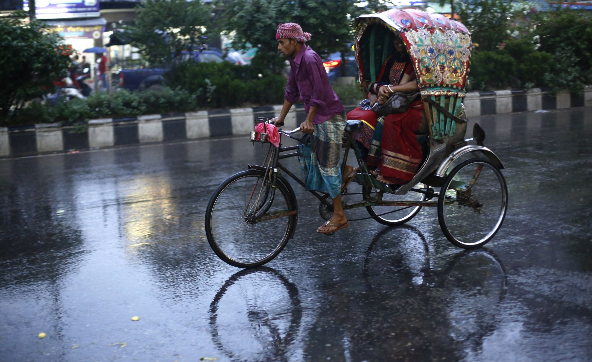 epa05997417 A rickshaw puller carries a passenger during rainy weather in Dhaka, Bangladesh, 29 May 2017. Cyclonic storm 'Mora' heads towards Bangladesh's coastal areas including Cox'sbazar, Chittagong, Barisal, Pyra, and Mongla, according to the Bangladesh Meteorological Department. The cyclone is going to cross Chittagong areas on 30 May.  EPA/ABIR ABDULLAH