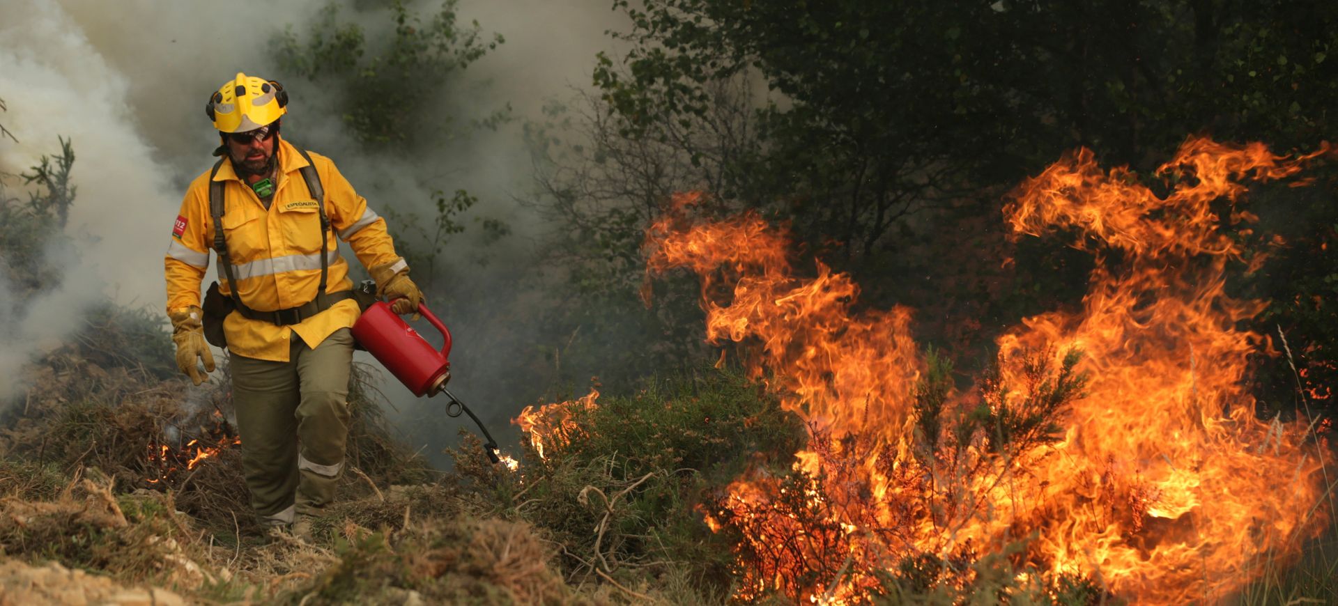 epa06041990 A Spanish specialist firefighter ignites a controlled fire on Alto do Soeirinho, as they fight the forest fire in Pampilhosa da Serra, center of Portugal, 21 June 2017. The wildfires in the center of Portugal gather 1153 firemen, 403 land vehicules, and 14 planes and helicopters.  EPA/TIAGO PETINGA