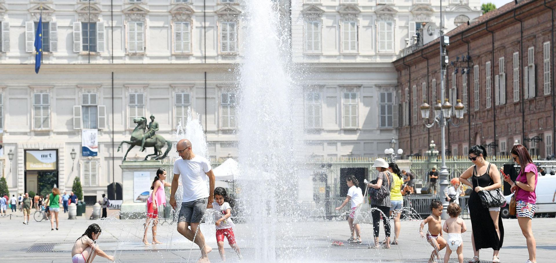 epa06047345 People refresh themselves at the Castello square fountains in Turin, northwest Italy, 24 June 2017. A heat wave has been affecting Italy for several days with temperatures of over 30 degrees Celsius.  EPA/ALESSANDRO DI MARCO