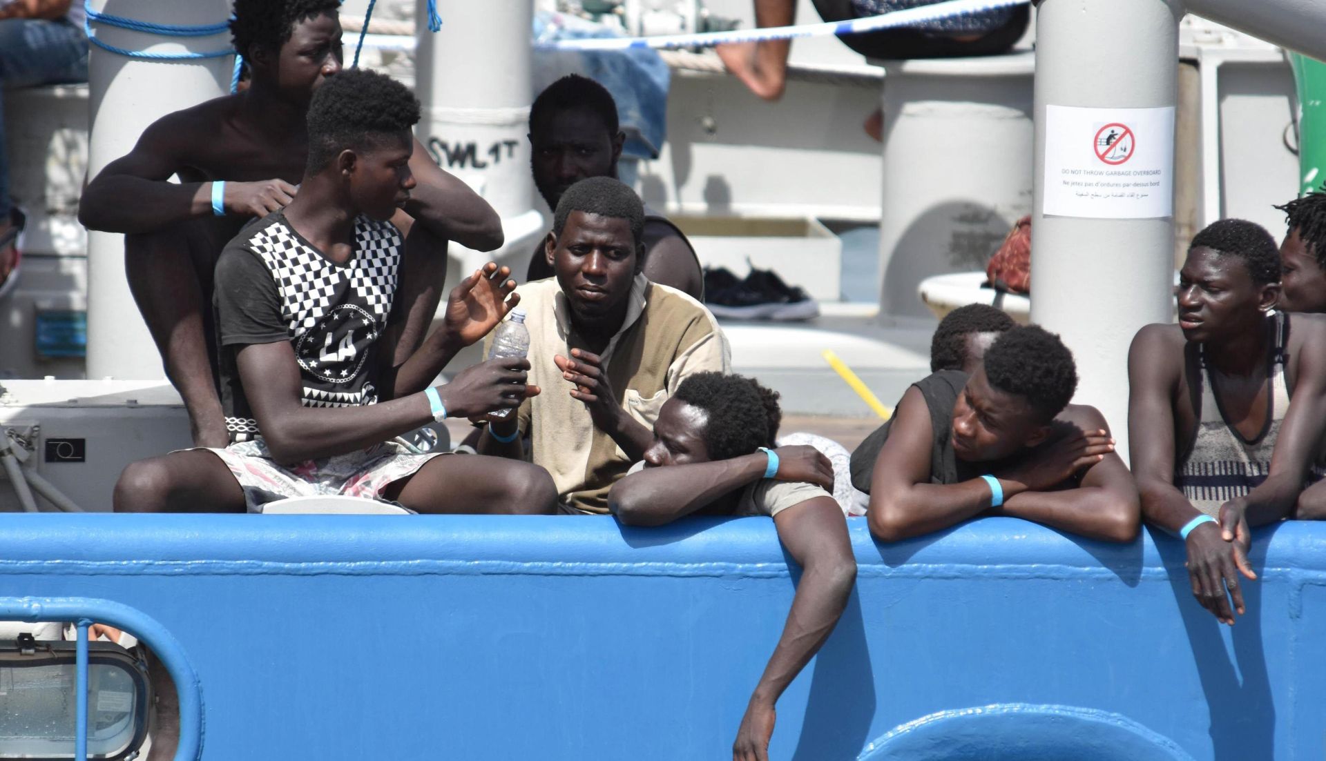 epa06059390 Some of the 650 migrants who were rescued by the Swedish ship Frontex in Mediterranean Sea off the Libyan coast, wait to disembark  in Catania, Italy, 01 July 2017. Nine migrants from the group were found dead. Italy has experienced a surge in refugee and migrant arrivals in recent months, and media outlets report that the Italian government is considering blocking boats carrying migrants from landing at its ports.  EPA/ORIETTA SCARDINO