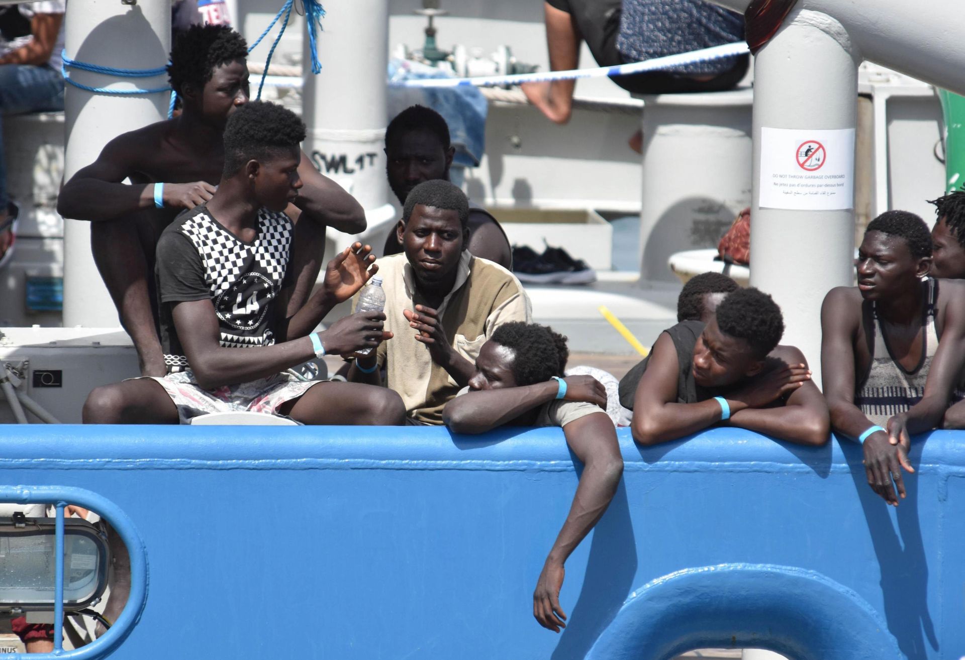 epa06059390 Some of the 650 migrants who were rescued by the Swedish ship Frontex in Mediterranean Sea off the Libyan coast, wait to disembark  in Catania, Italy, 01 July 2017. Nine migrants from the group were found dead. Italy has experienced a surge in refugee and migrant arrivals in recent months, and media outlets report that the Italian government is considering blocking boats carrying migrants from landing at its ports.  EPA/ORIETTA SCARDINO