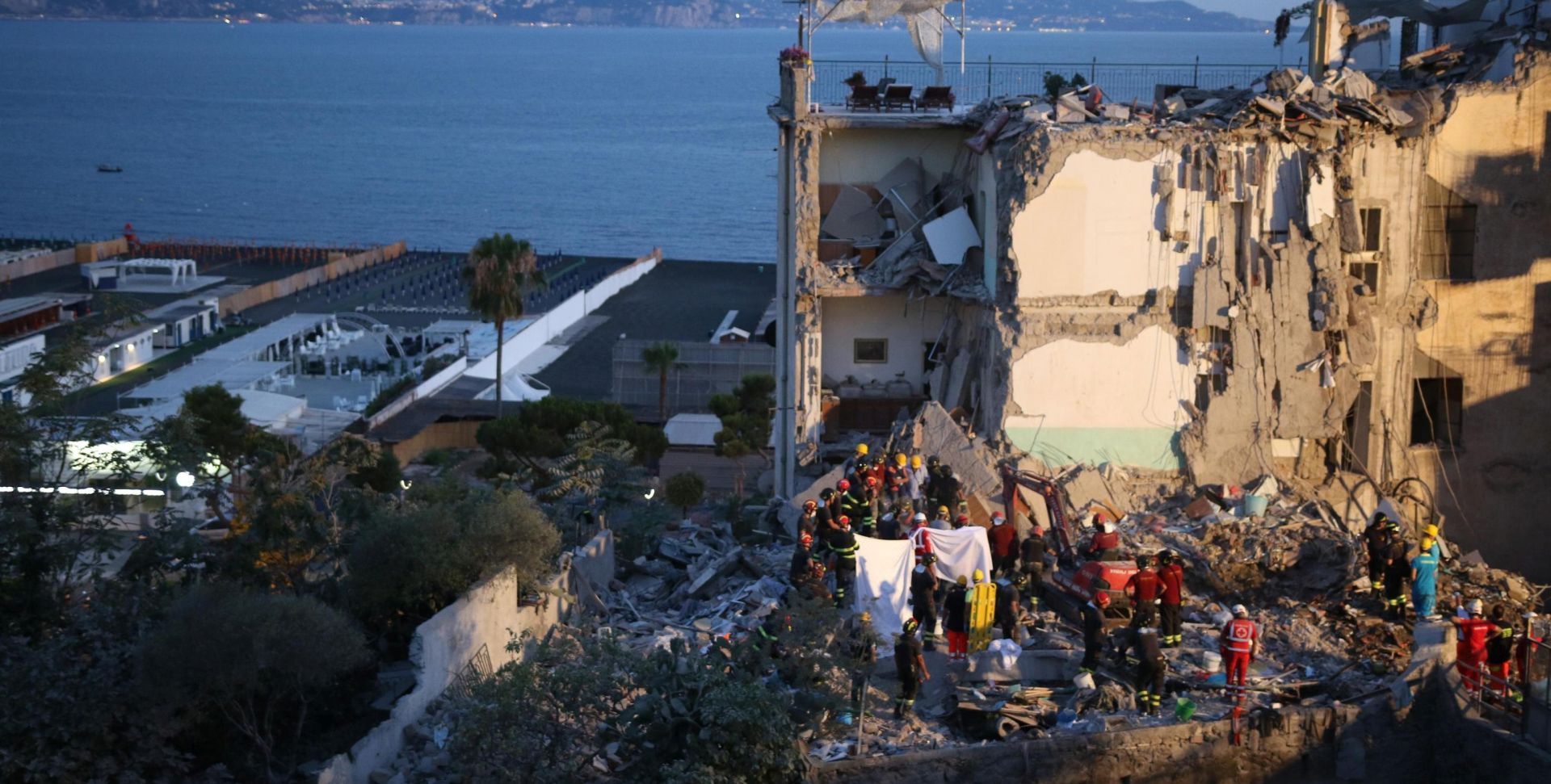 epa06074388 Rescuers at work amid the rubble of a building that collapsed in Torre Annunziata, near Naples, southern Italy, 07 July 2017. Torre Annunziata Mayor Vincenzo Ascione said seven people were missing, including two children, after an apartment building collapsed in the southern city near Naples.  EPA/CESARE ABBATE