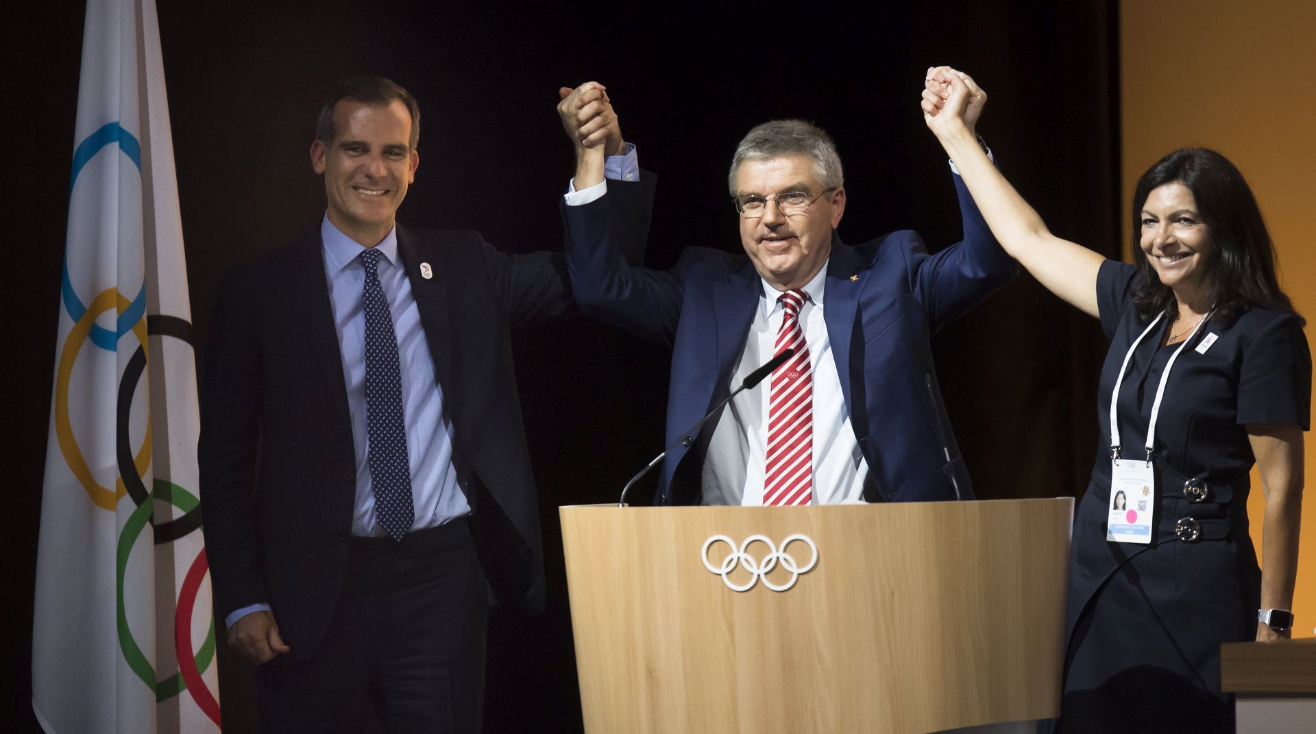 epa06081510 (L-R) Mayor of Los Angeles Eric Garcetti, International Olympic Committee (IOC) President Thomas Bach, and Paris Mayoress Anne Hidalgo pose together during the International Olympic Committee (IOC) Extraordinary Session, at the SwissTech Convention Centre, in Lausanne, Switzerland, 11 July 2017. The session decided to adopt the proposal of the Executive Board to award the Olympic Games 2024 and 2028 at the same time,  EPA/JEAN-CHRISTOPHE BOTT