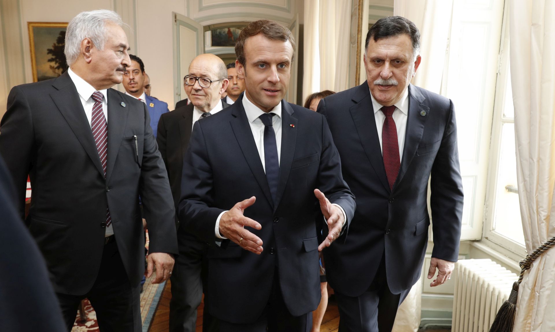epa06108791 French President Emmanuel Macron (C) walks with Libyan Prime Minister Fayez al-Sarraj (R), General Khalifa Haftar (L), commander in the Libyan National Army (LNA), and French Europe and Foreign Minister Jean-Yves Le Drian (2ndL) before a meeting for talks over a political deal to help end Libyas crisis in La Celle-Saint-Cloud near Paris, France, 25 July 2017.  EPA/PHILIPPE WOJAZER / POOL MAXPPP OUT