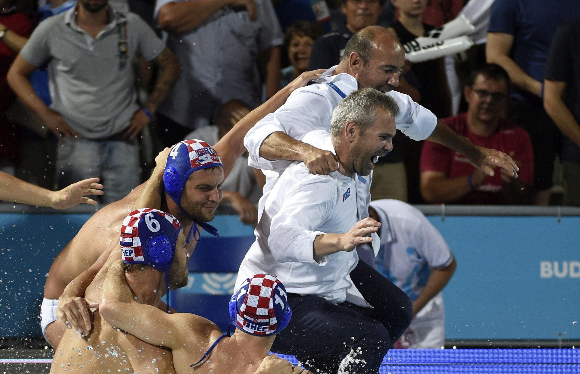 epa06116776 Head coach Ivica Tucak (rear) of Croatia jumps into the water to celebrate with his players after his team won the men's water polo final match Hungary vs Croatia at the 17th FINA Swimming World Championships in Hajos Alfred National Swimming Pool in Budapest, Hungary, 29 July 2017.  EPA/Balazs Czagany HUNGARY OUT