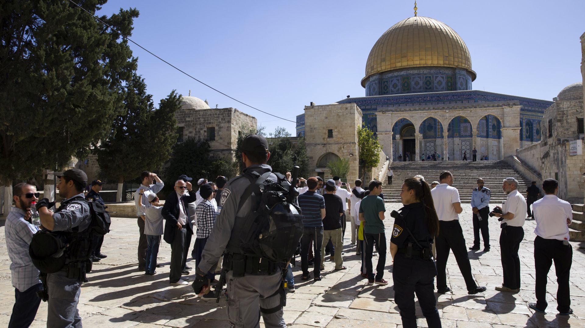 epa06117231 Israeli riot police personnel escort a group of religious Israeli Jews near the distinctive golden Dome of the Rock as they tour the Temple Mount, or Haram el-Sharif (The Noble Sanctuary) as it is known to Arabs, in Jerusalem's Old City, 30 July 2017. The area was closed to tourism during some two weeks of tension and clashes following the attack on Israeli security guards on 14 July 2017, and has now resumed after Israeli removed the controversial metal detectors and cameras or the al-Aqsa Mosque compound.  EPA/JIM HOLLANDER