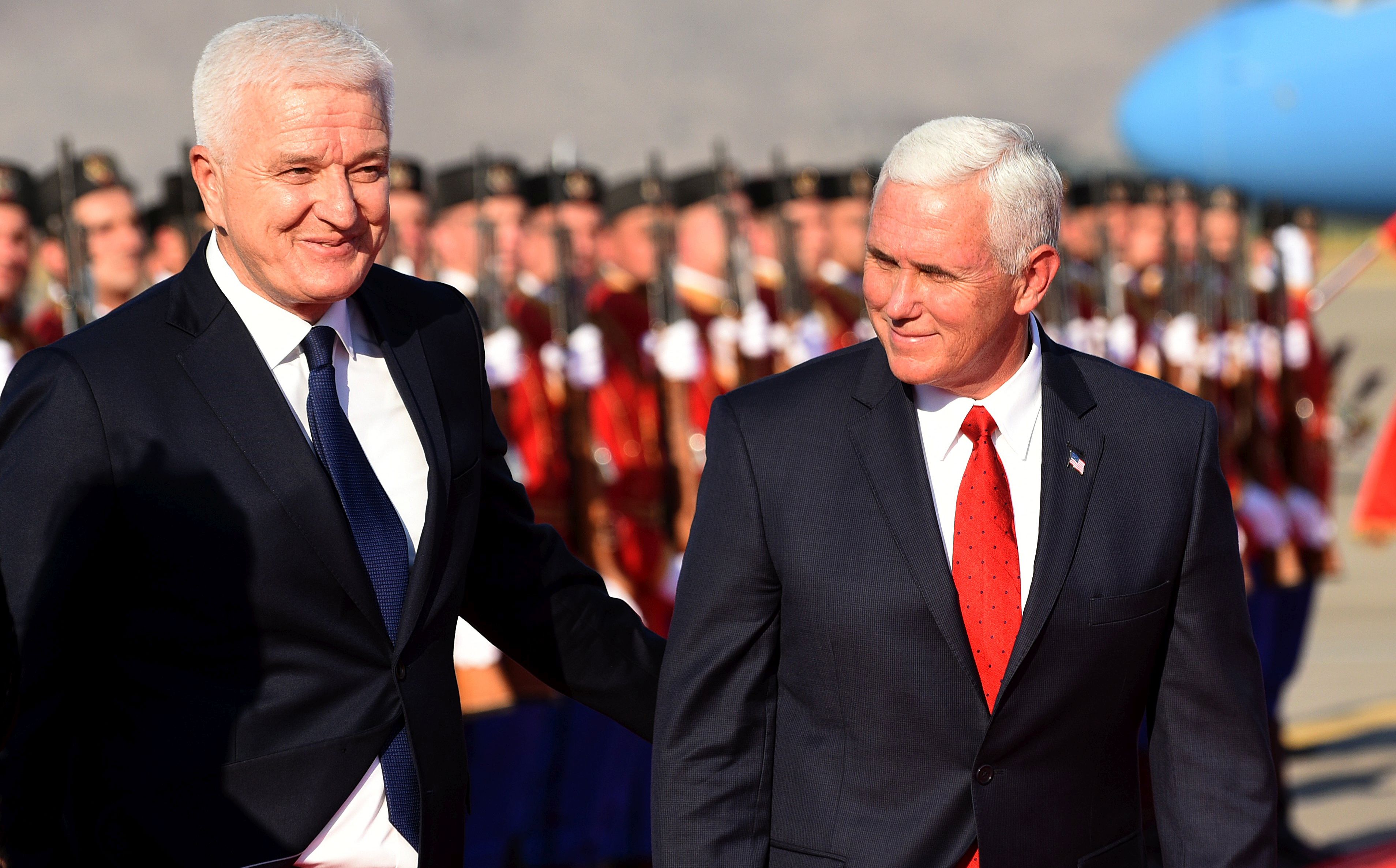 epa06120198 US Vice President Mike Pence (L) and Montenegrian Prime Minister Dusko Markovic (R) attend an official welcome ceremony at the airport Golubovci, Podgorica, Montenegro, 01 August 2017. Pence was in Estonia and Georgia for a visit before continuing to  Montenegro. Pence will attend the  Adriatic Charter Summit, to be hosted by Montenegro and the Republic of Macedonia on 02 August  in Podgorica, Montenegro.  EPA/BORIS PEJOVIC