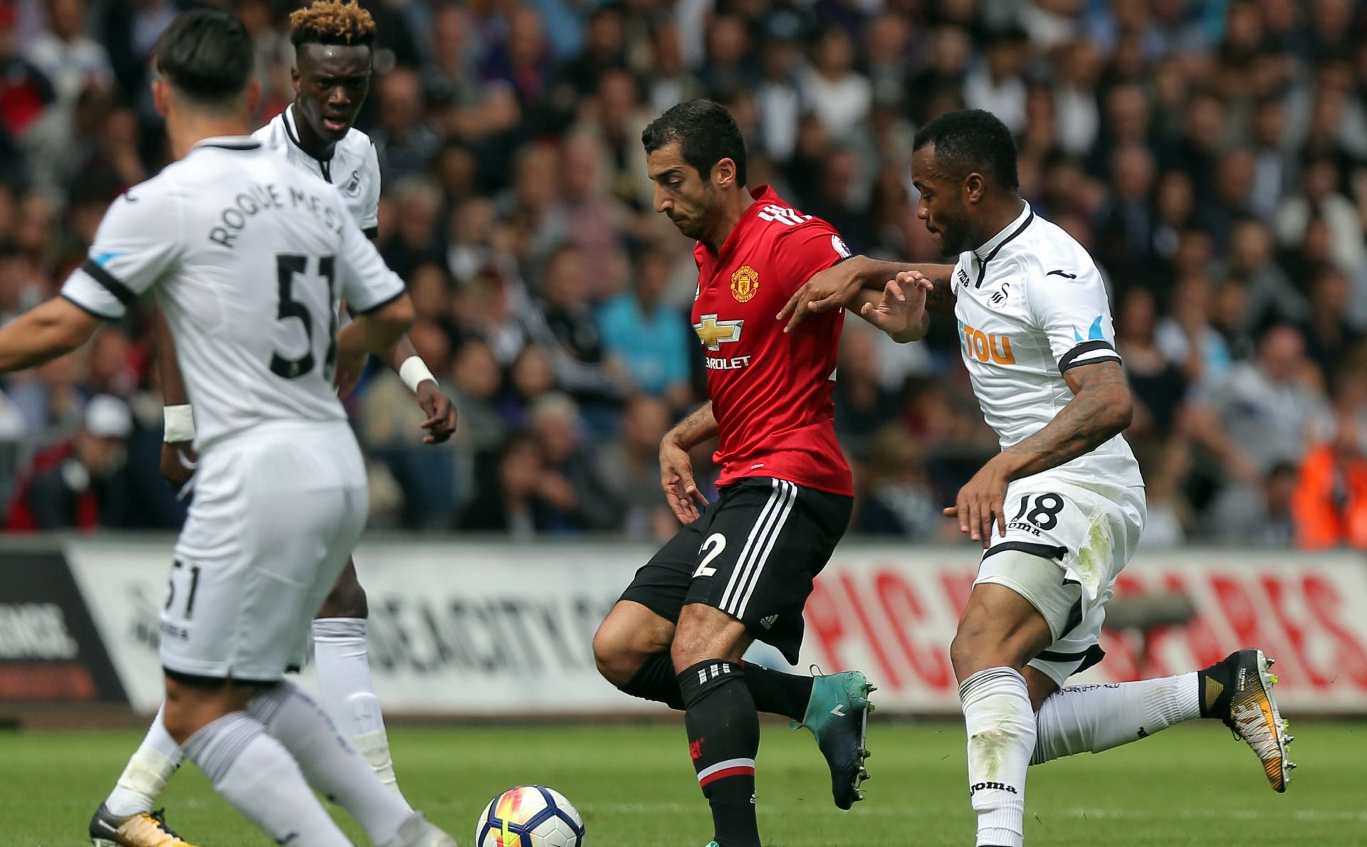 epa06151228 Henrikh Mkhitaryan of Manchester United (C) challenged by Jordan Ayew of Swansea City Jordan Ayew of Swansea City during the English Premier League soccer match between Swansea City and Manchester United at Liberty Stadium, Swansea, Britain, 19 August 2017.  EPA/DIMITRIS LEGAKIS EDITORIAL USE ONLY. No use with unauthorized audio, video, data, fixture lists, club/league logos or 'live' services. Online in-match use limited to 75 images, no video emulation. No use in betting, games or single club/league/player publications