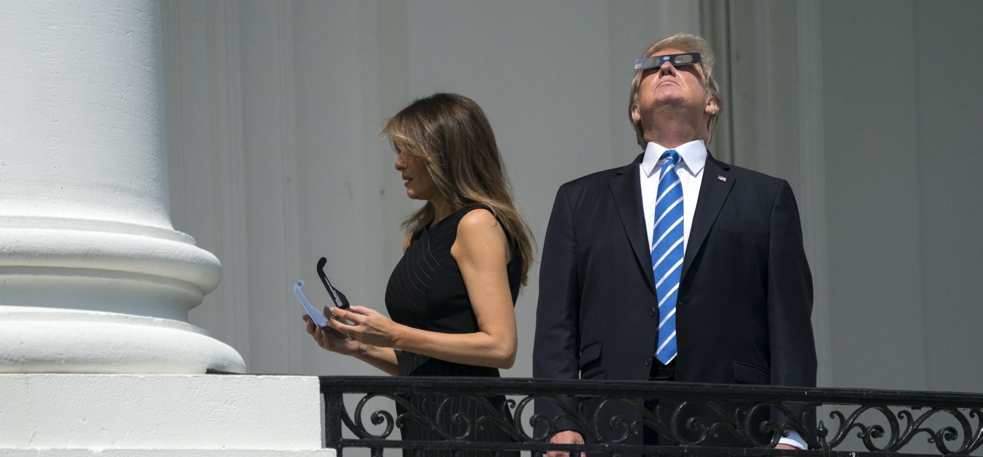 epa06155377 US President Donald J. Trump (R) and First Lady Melania Trump (L) view the solar eclipse from a balcony of the White House in Washington, DC, USA, 21 August 2017. The 21 August 2017 total solar eclipse will last a maximum of 2 minutes 43 seconds and the thin path of totality will pass through portions of 14 US states, according to the National Aeronautics and Space Administration (NASA).  EPA/SHAWN THEW