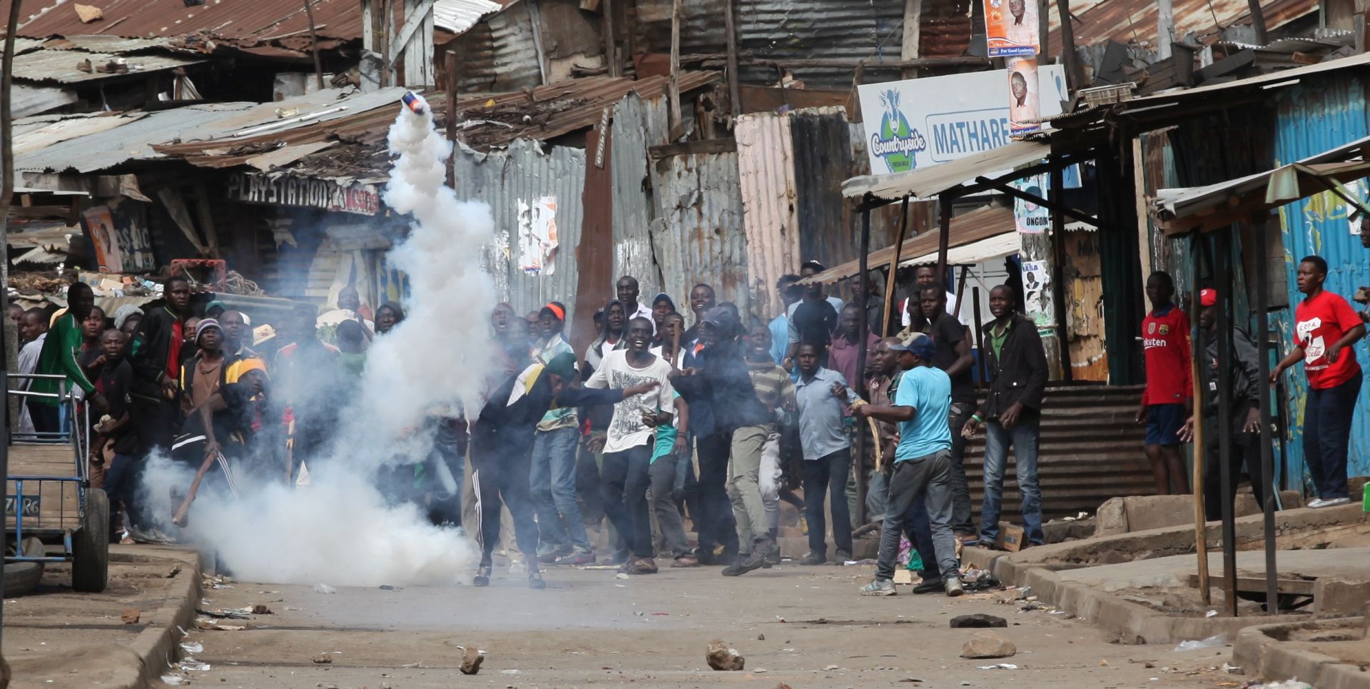 epa06139751 Supporters of the opposition leader Raila Odinga shout slogans as they throw back a tear gas canister thrown to them by riot police officers  during a protest in Mathare slum, in Nairobi, Kenya, 12 August 2017. On 11 August the electoral body decleared incumbent Uhuru Kenyatta as the winner in the presidential election. According to the vote count Uhuru beat opposition leader Raila Odinga. Odinga and other opposition leaders are disputing the results. Police are beefing up security on Nairobi streets as the fear of the post-election violence looms.  EPA/DANIEL IRUNGU