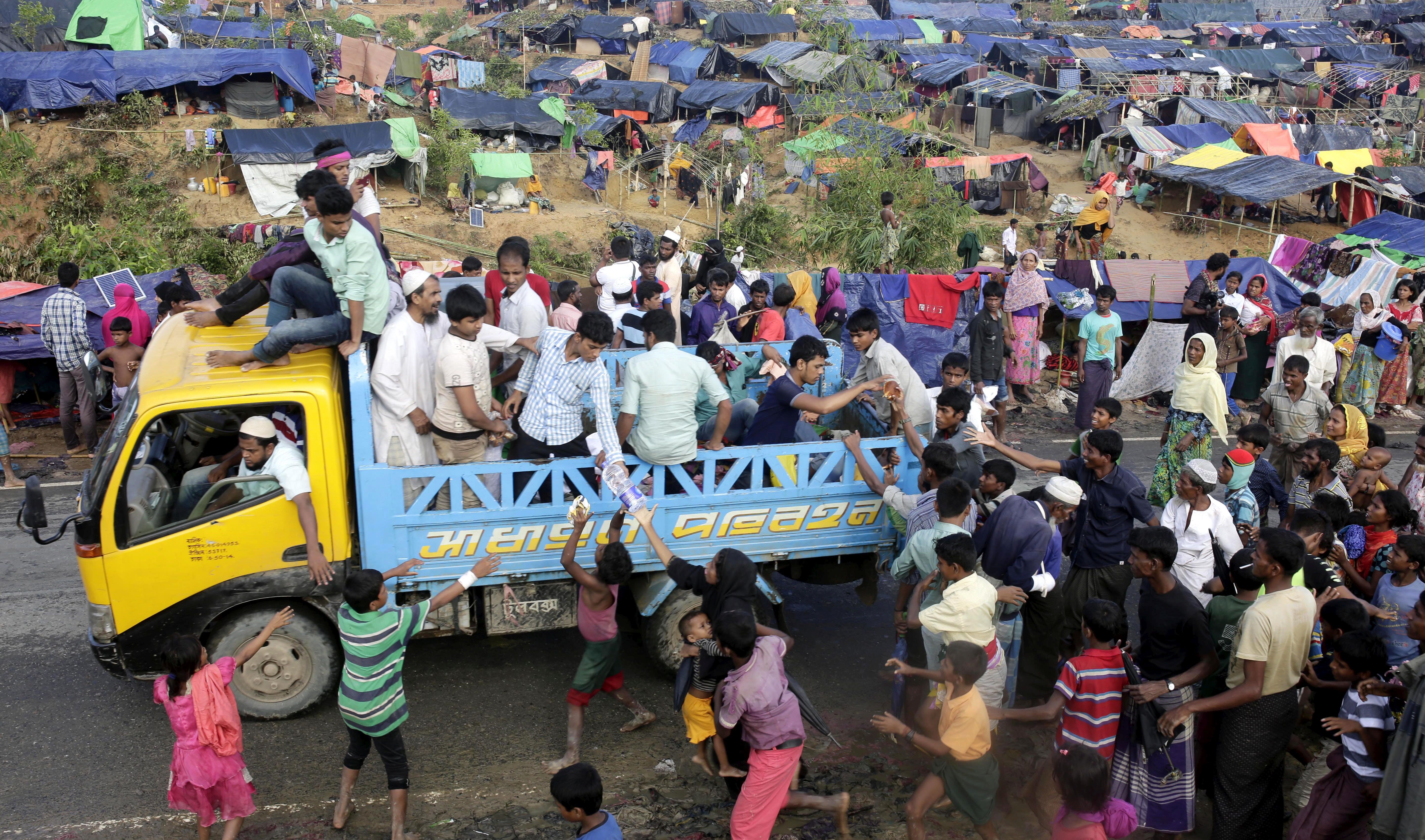 epa06210705 Rohingya refugees try to catch the relief from a truck at Tangkhali, Ukhiya, Bangladesh, 17 September 2017. According to UNHCR more than 400 thousand Rohingya refugees have fled Myanmar from violence over the last few weeks, most trying to cross the border and reach Bangladesh. International organizations have reported claims of human rights violations and summary executions allegedly carried out by the Myanmar army.  EPA/ABIR ABDULLAH