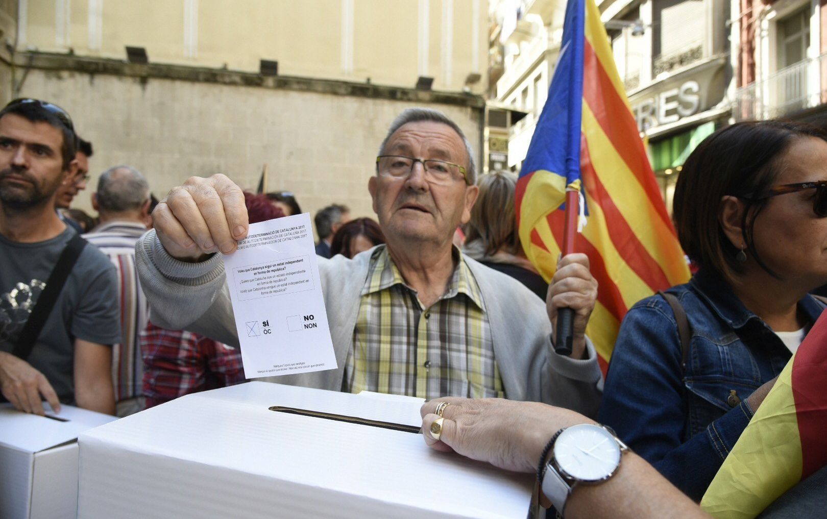 epa06215724 A man casts a mock ballot as hundreds of people gather to protest against the police searches at plaza Paeria, in Lleida, Catalonia, northeastern Spain, 20 September 2017. Spanish Civil Guard carried out different searches for documents related to the '1-O Referendum' resulting in the arrest of 14 people, including some Catalan Government's top officials, according to sources of the investigation. Thousands of Catalans took the streets to protest against the police's action.  EPA/Adria Ropero
