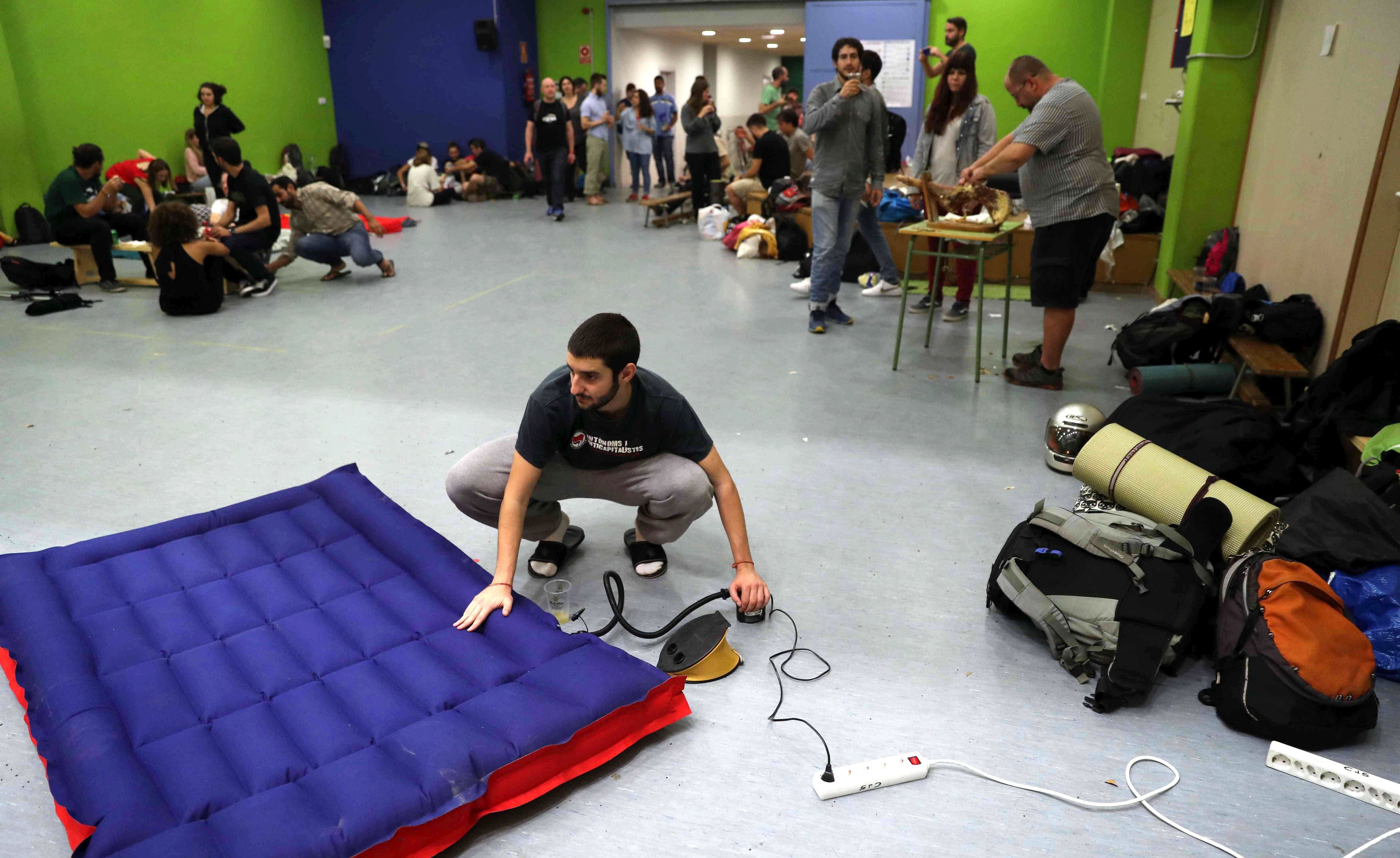epa06235660 A Catalan pro-independence man prepares an air mattress to spend the night inside the Jaume I school in Barcelona, northeastern Spain, early 30 September 2017. Hundreds of people have spent the night in different schools and civic centers designated by the regional Government to be polling stations for the '1-O Referendum' in an attempt to prevent the police from avoid their use, as the Superior Court of Justice of Catalonia ordered. Catalonian Government has planned a total of 2,315 polling stations and 6,249 officials in charge of them in all the region, as well as some 7,235 people in charge of securing the chances to vote to some 5,343.358 Catalans. Until the date, the Catalan police (Mossos d'Esquadra) has checked some 1,300 polling stations, of which 163 have been occupied at the moment, meaning a 12 per cent of the total number.  EPA/Toni Albir