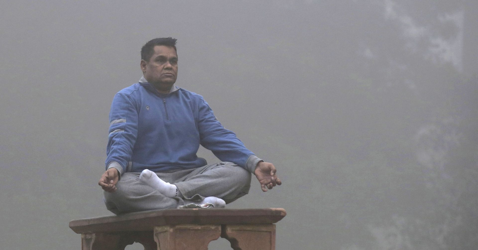 epa06314939 An Indian man meditates as the Lodhi garden is engulfed in heavy smog during early morning in New Delhi, India, 08 November 2017. People in the Indian capital city are struggling with heavily polluted air as air quality hit 'severe levels,' according to reports.  EPA/RAJAT GUPTA