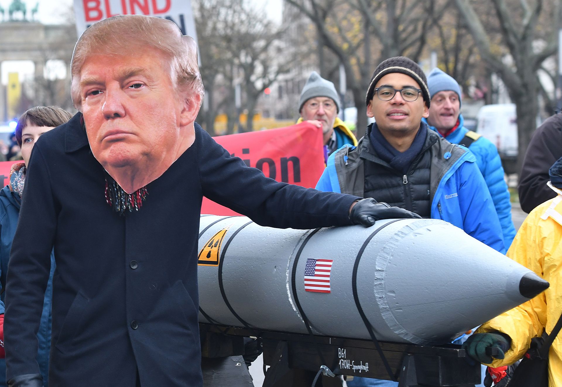 A protestor wearing a mask of US President Donald Trump puts his hands on a mock missile during a demonstration against nuclear weapons politics under the slogan "Stop the escalation - prohibit nuclear weapons!", in Berlin, Germany, 18 November 2017. Photo: Paul Zinken/dpa