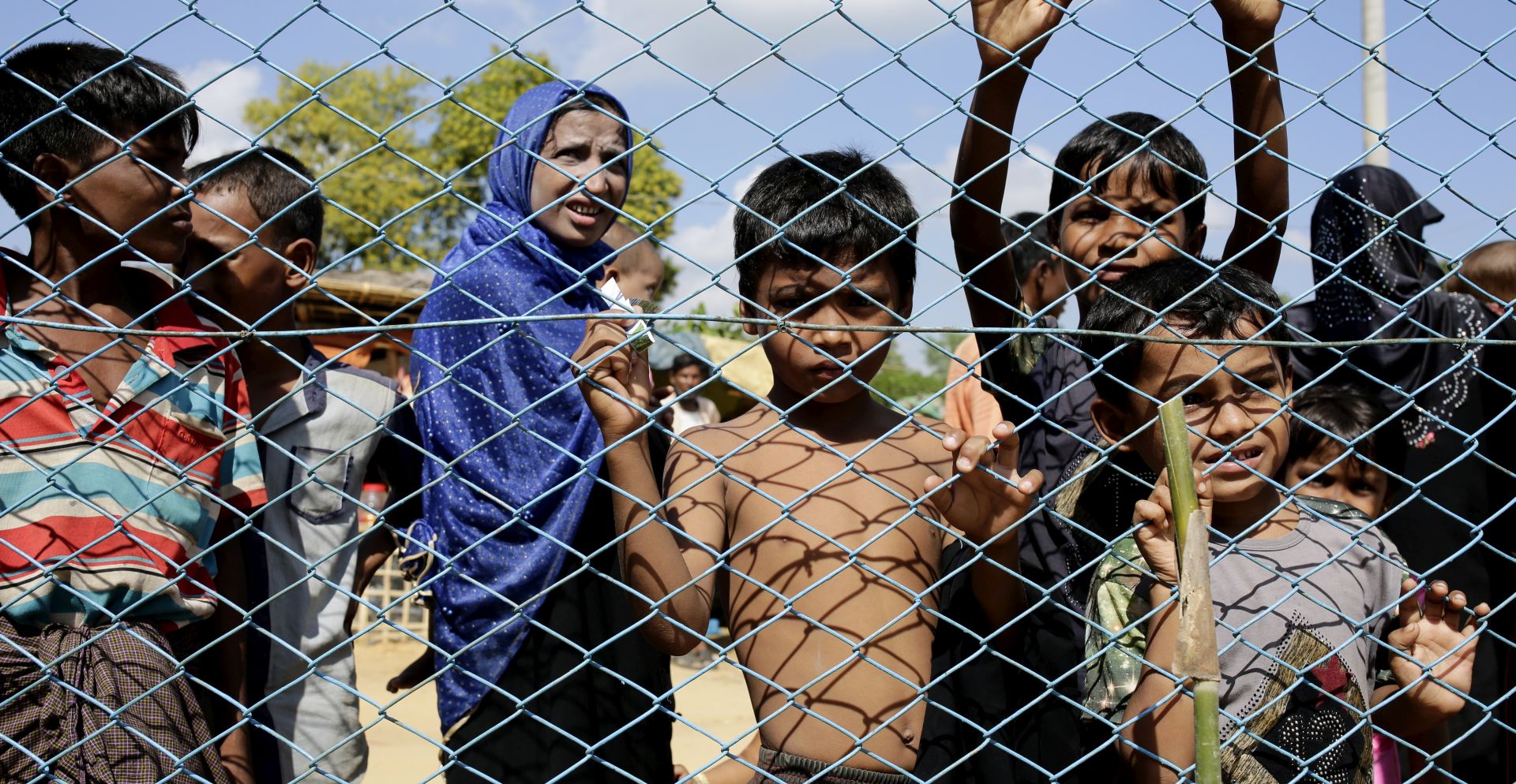 epa06338520 Rohngya refugees including children and women wait outside a fence of a health clinic at the Kutupalong, Coxabazar in Bangladesh 19 November 2017.  International politicians are currently on a fact finding tour to gather information about the Rohingya crisis, while Bangladesh hopes for international help and support for the refugees.  EPA/ABIR ABDULLAH