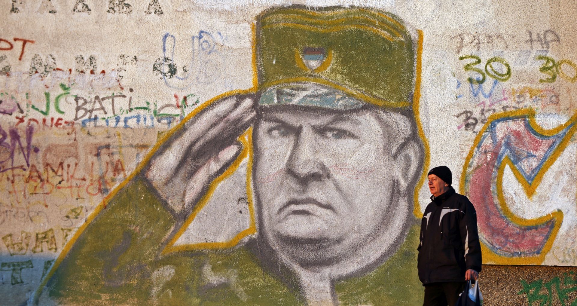 epa06342087 (FILE) - A man walks in front of a mural depicting Serbian General Ratko Mladic, a war-time Bosnian Serb military commander, in a suburb of Belgrade, Serbia, 12 December 2016 (reissued 21 November 2017). The United Nations International Criminal Tribunal for the former Yugoslavia (ICTY) will on 22 November 2017 announce the verdict on Mladic in The Hague, the Netherlands. Mladic, who was Commander of the Bosnian Serb Army (VRS) Main Staff from May 1992 until at least November 1996, is indicted with counts of genocide, crimes against humanity, and violations of the laws or customs of war.  EPA/KOCA SULEJMANOVIC *** Local Caption *** 53155793