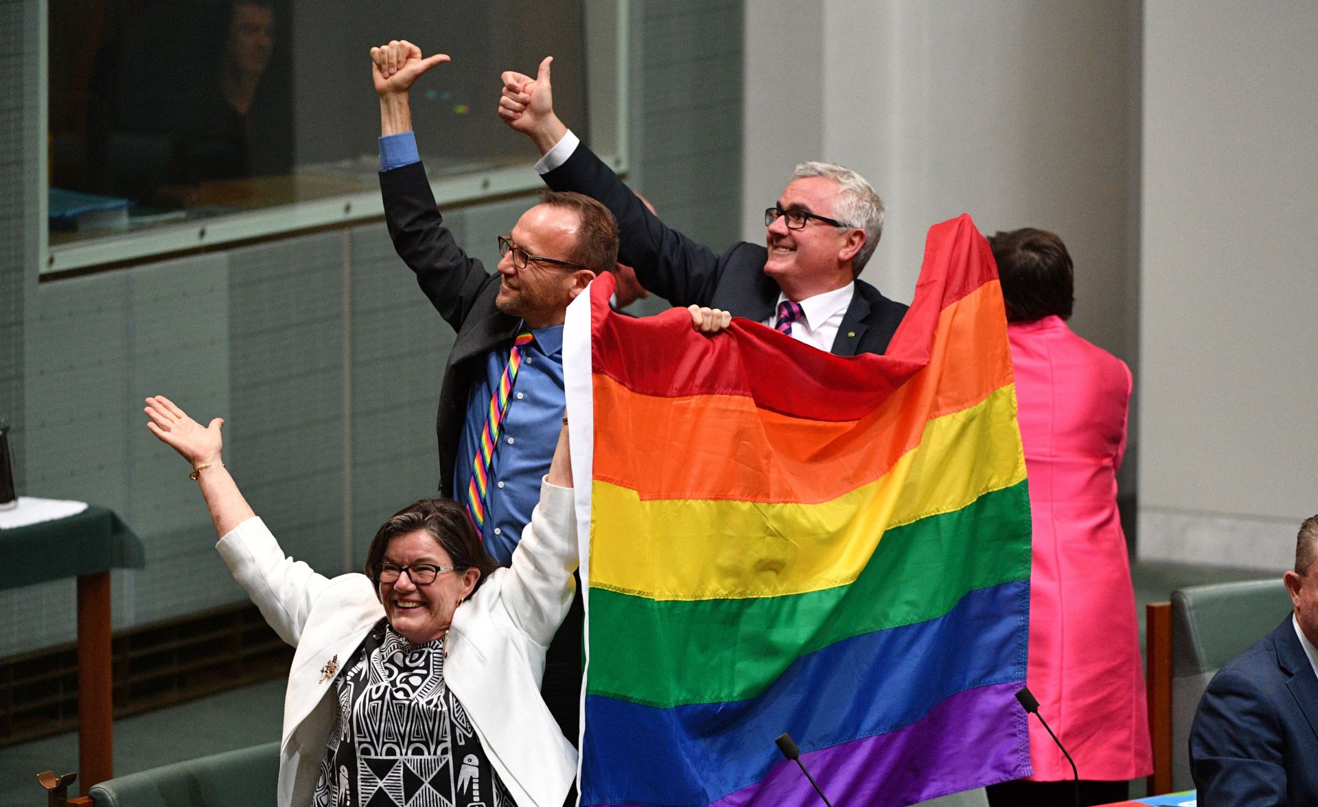 epa06373156 MPs Cathy McGowan (L), Adam Brandt (C) and Andrew Wilkie (R) celebrate the passing of the Marriage Amendment Bill in the House of Representatives at Parliament House in Canberra, Australia, 07 December 2017. The passage of the bill effectively legalizes same-sex marriage in Australia.  EPA/MICK TSIKAS  AUSTRALIA AND NEW ZEALAND OUT