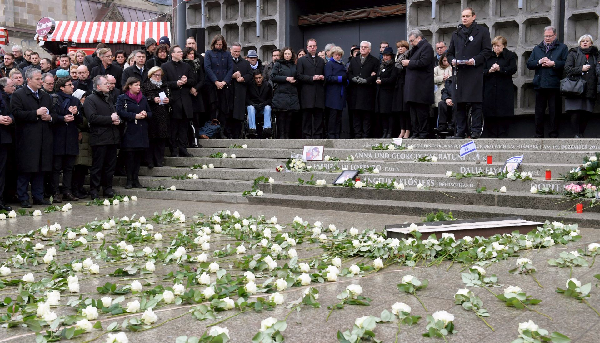 epa06398328 Mourners attend the commemorative events marking the first anniversary of the terrorist attack on Christmas market at Breitscheidplatz in Berlin, Germany, 19 December 2017. The Breitscheidplatz square in Berlin on the same day in 2016 was the target of a terror attack in which 12 people lost their lives and around 50 others were injured, when a truck driven by Anis Amri plowed through the Christmas market.  EPA/CLEMENS BILAN
