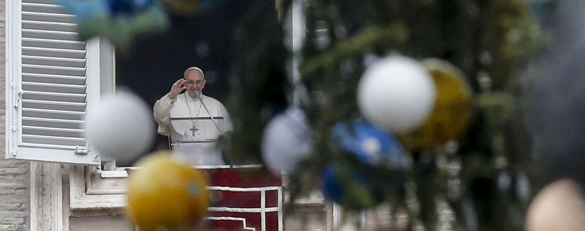 epa06412406 Pope Francis is framed through the Vatican Christmas tree as he leads the Angelus prayer on the 51st world day of Peace on the theme Migrants and refugees: men and women in search of peace, in Saint Peters Square at the Vatican, 01 January 2018.  EPA/FABIO FRUSTACI